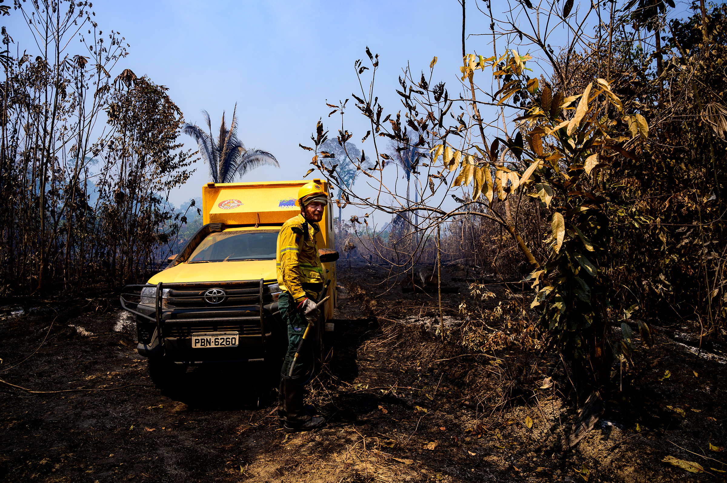 A worker and vehicle from Brazil's environmental agency, IBAMA, in a recently burned section of forest in the Vila Nova Samuel region on Aug. 28. (Sebastián Liste—NOOR for TIME)