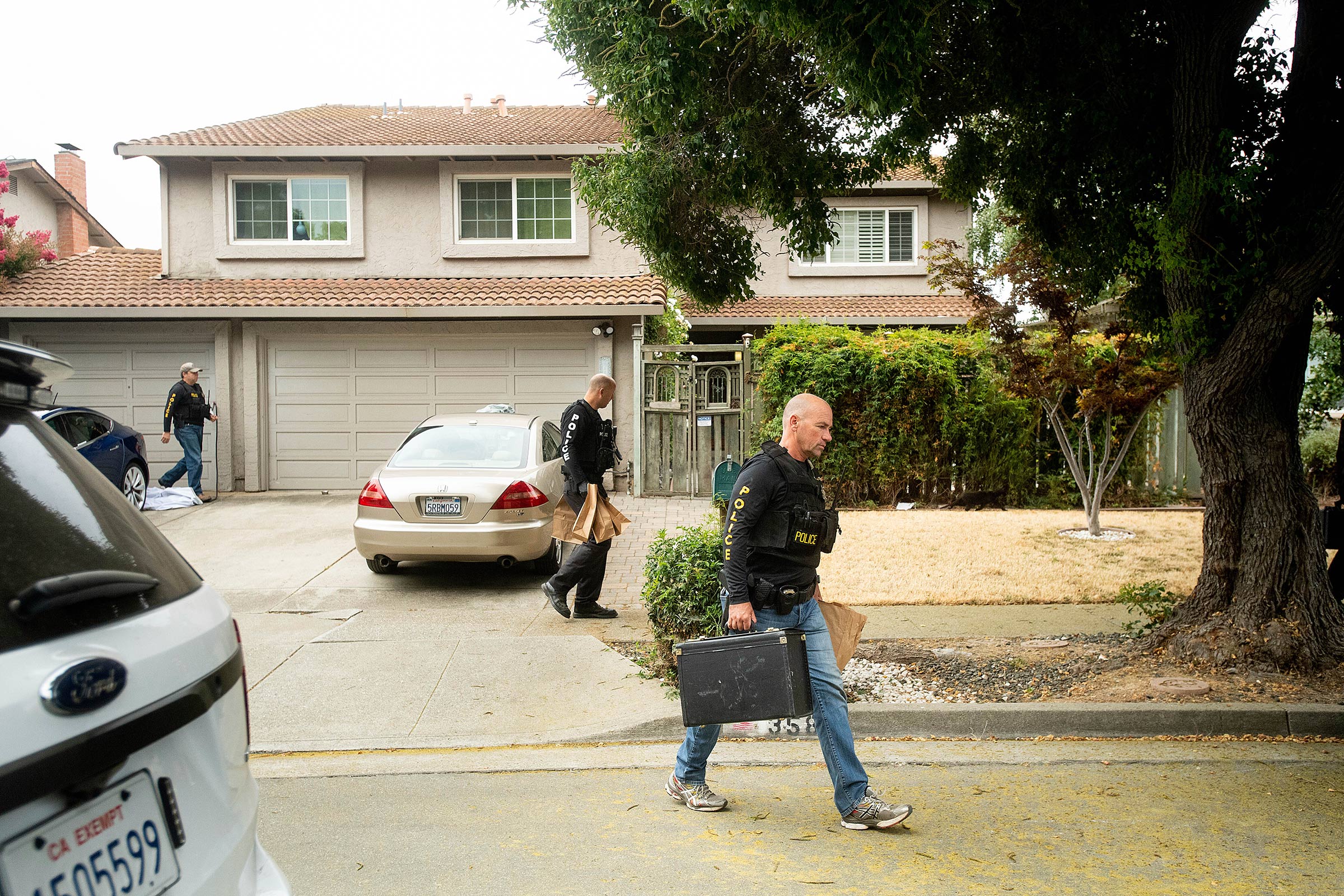 Police carry evidence bags from the home of the Gilroy shooting suspect.