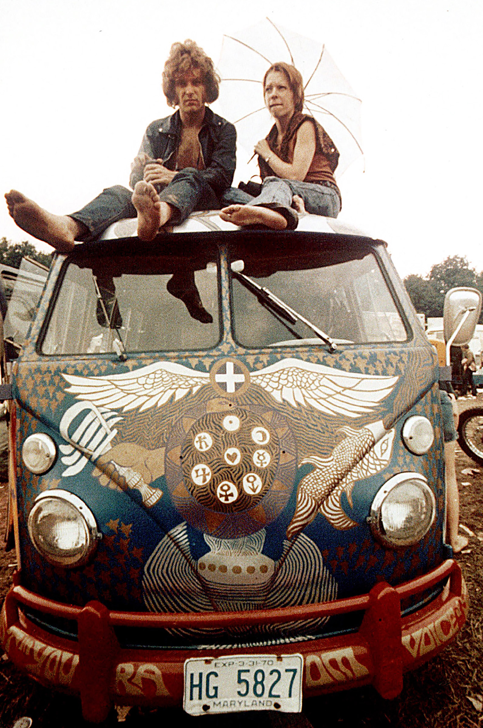 Concert-goers sit on the roof of a Volkswagen bus at the Woodstock Music and Arts Fair at Bethel, N.Y., in mid-August, 1969. (Ron Frem—AP)