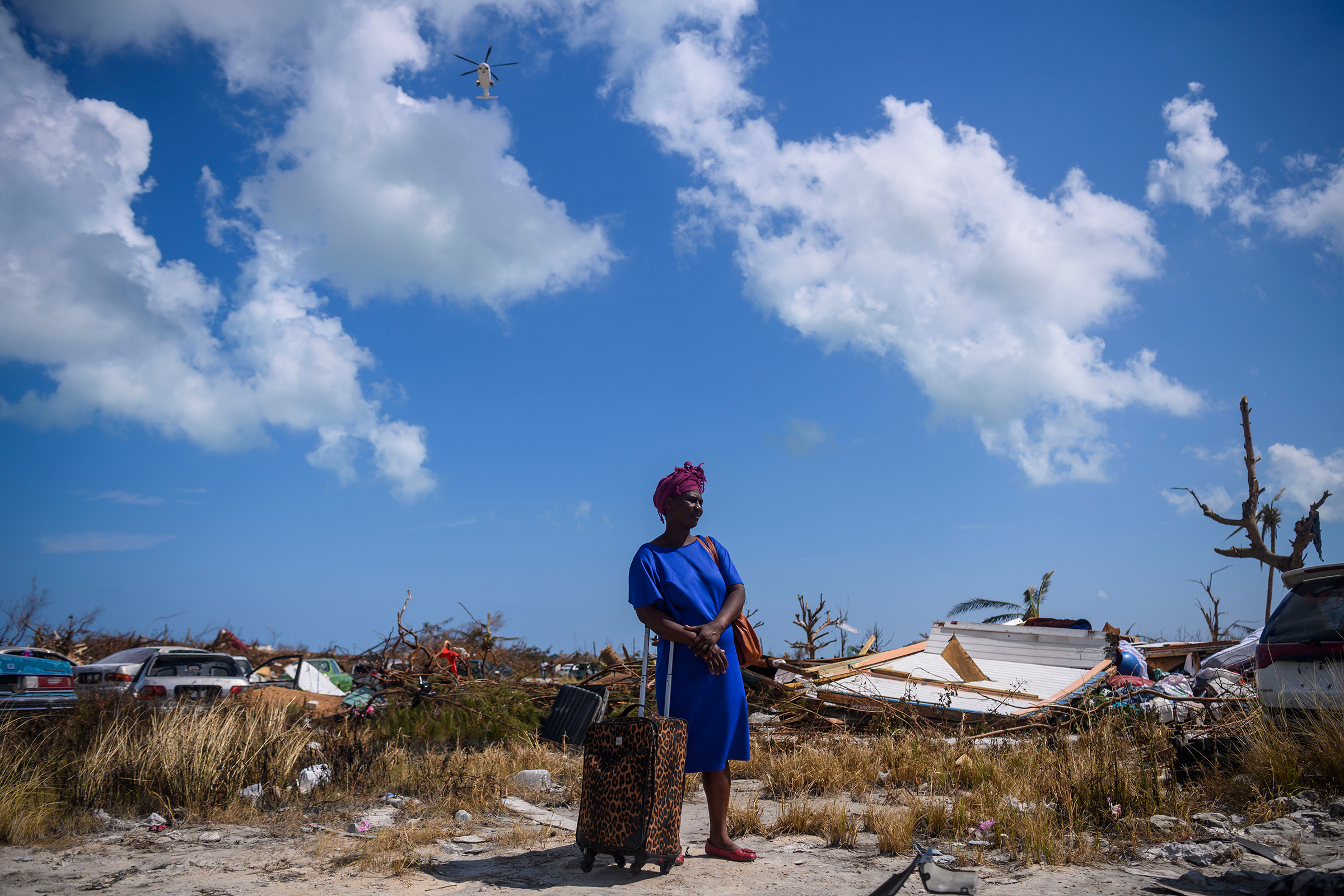Dejani Louistan, who was displaced by Hurricane Dorian, stands with the only belongings she managed to salvage amid the destruction left in the Mudd neighborhood of Marsh Harbour, Bahamas on September 7, 2019. (Carolyn Van Houten—The Washington Post via Getty Images)