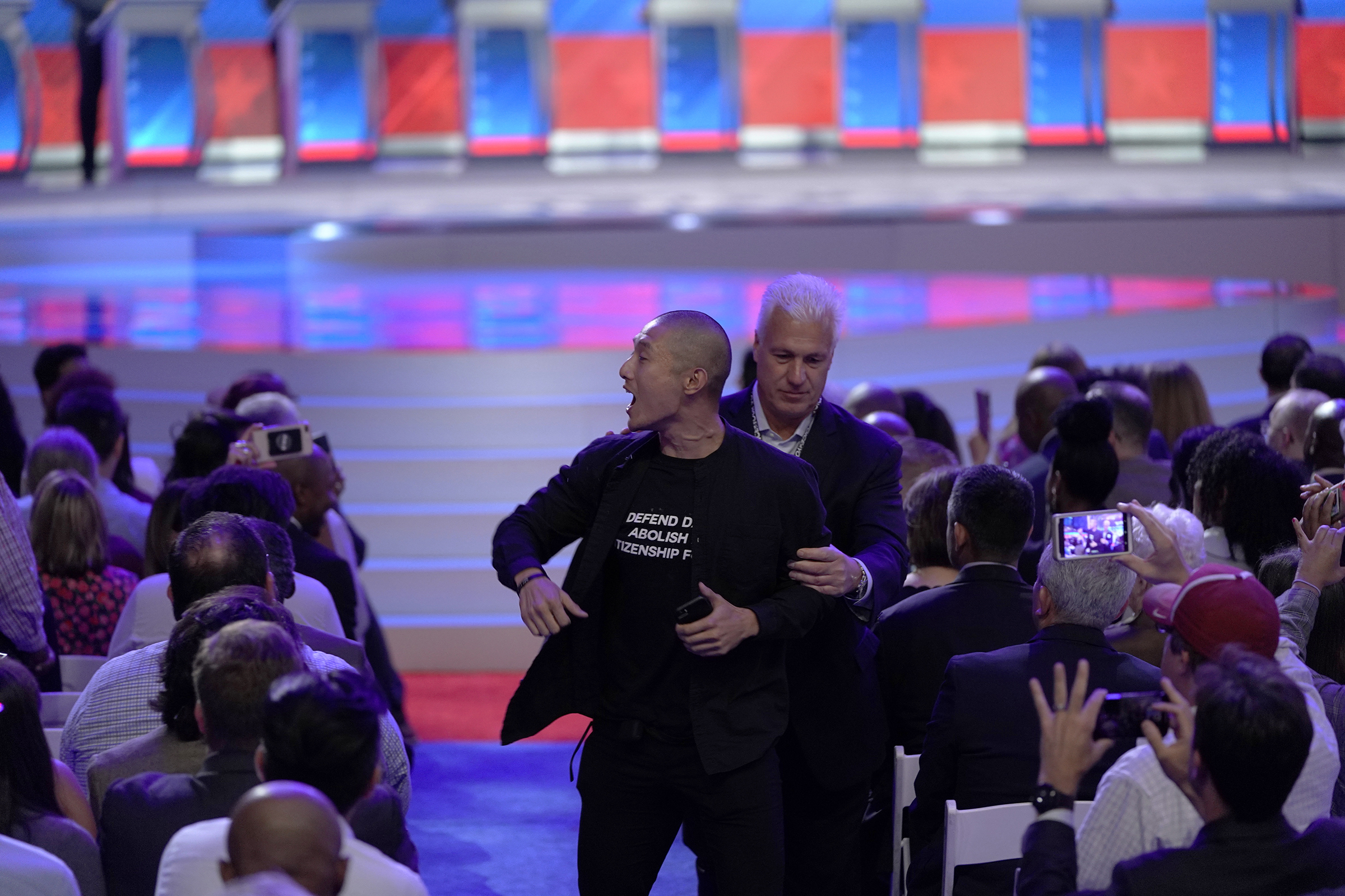 A protester is removed Sept. 12, 2019, after interrupting a Democratic presidential primary debate hosted by ABC at Texas Southern University in Houston. (David J. Phillip—AP)