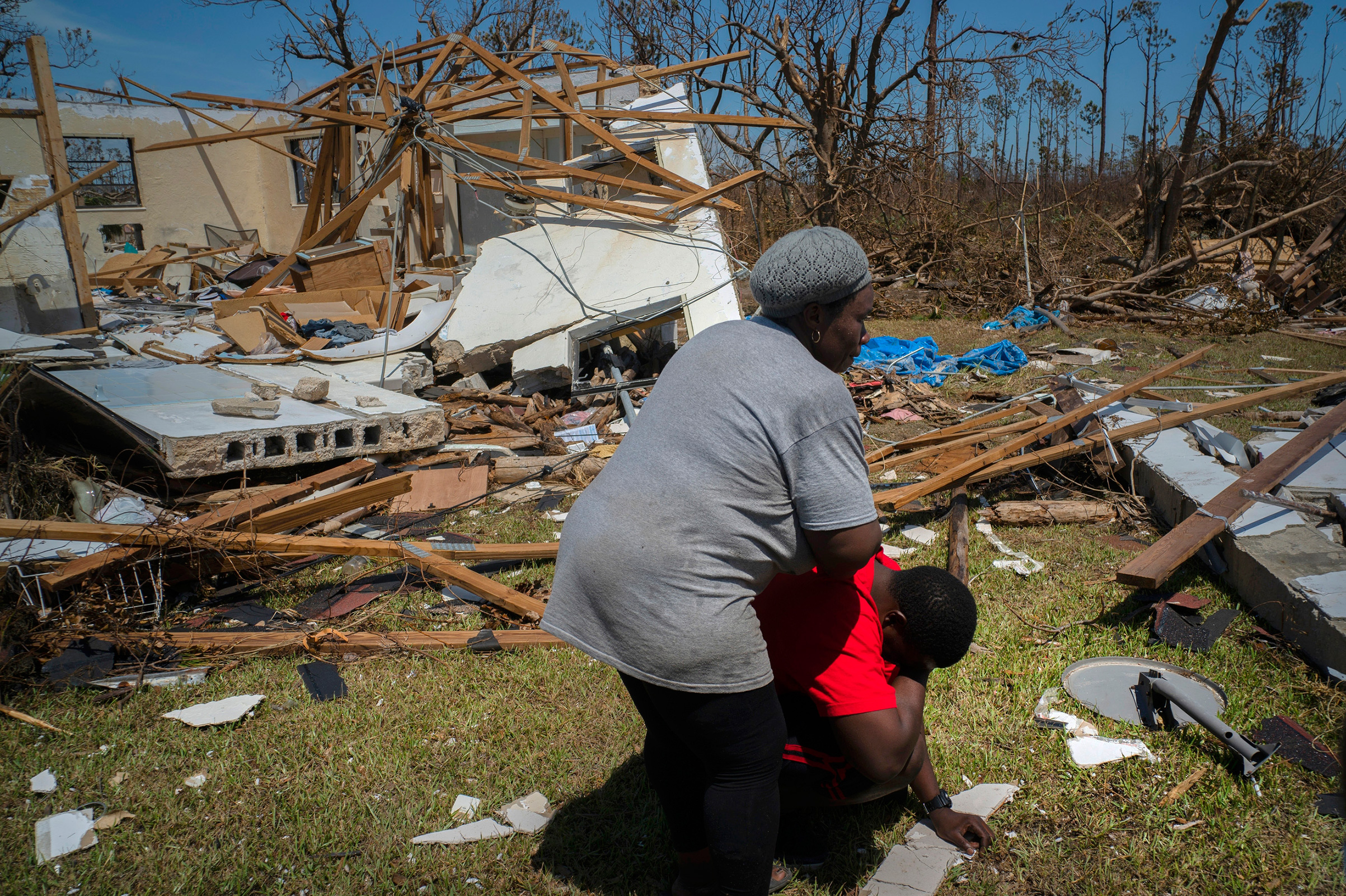 A woman comforts a man who cries after discovering his shattered house and not knowing anything about his eight missing relatives who lived there, High Rock, Grand Bahama, Bahamas, Thursday, Sept. 5, 2019. (Ramon Espinosa—AP)