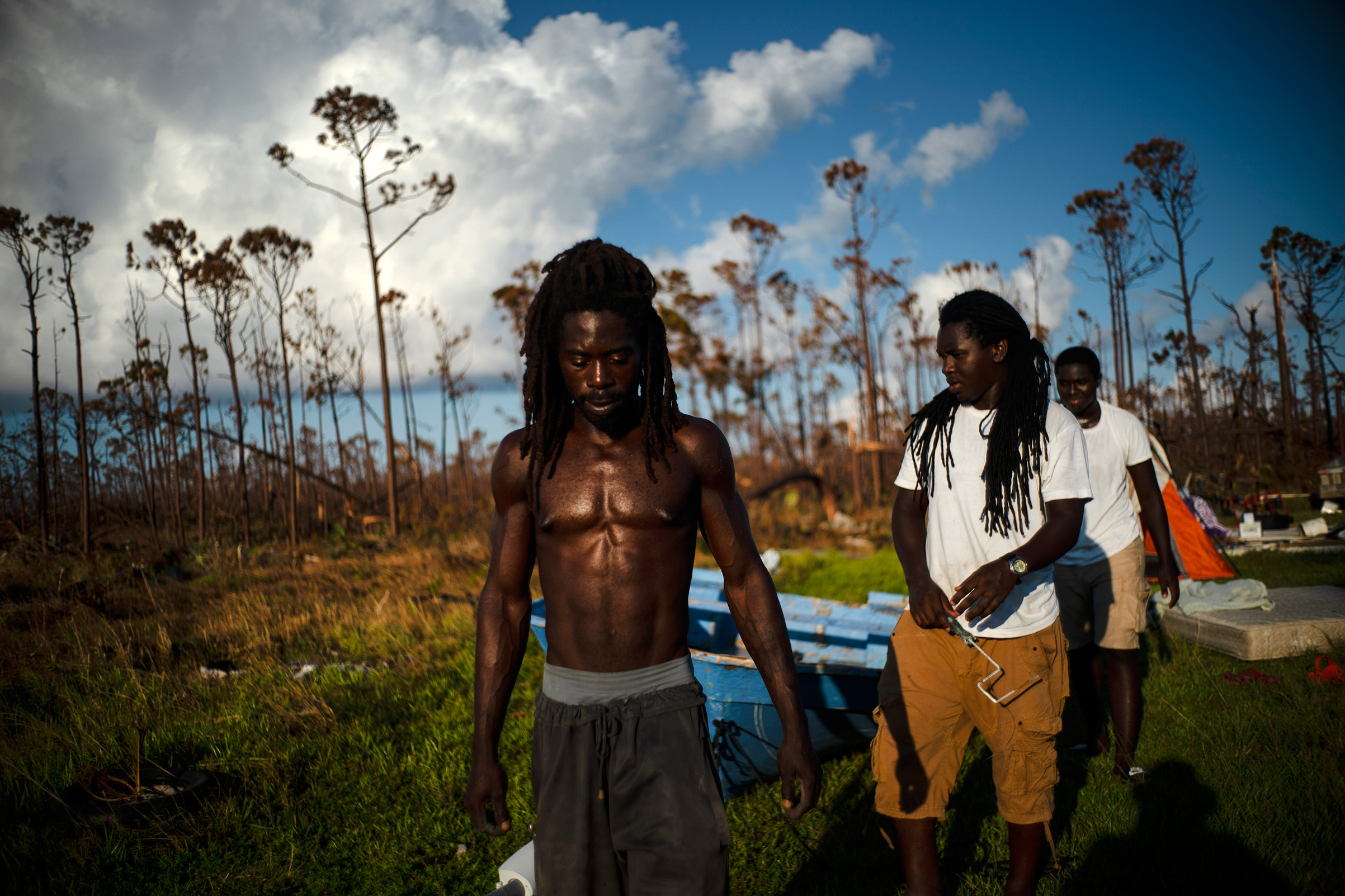 Dexter Edwards, front, his brother Nathanael Edwards right, and his cousin Valentino Ingraham walk amid one of their family's homes destroyed by Hurricane Dorian in Rocky Creek East End, Grand Bahama, Bahamas, Sept. 8, 2019. "Right now, ain't much joy. You just gotta try to keep your head up," Edwards said. "There's always a future. Only thing we can do right now is rebuild-rebuild and try to move forward." (Ramon Espinosa—AP)