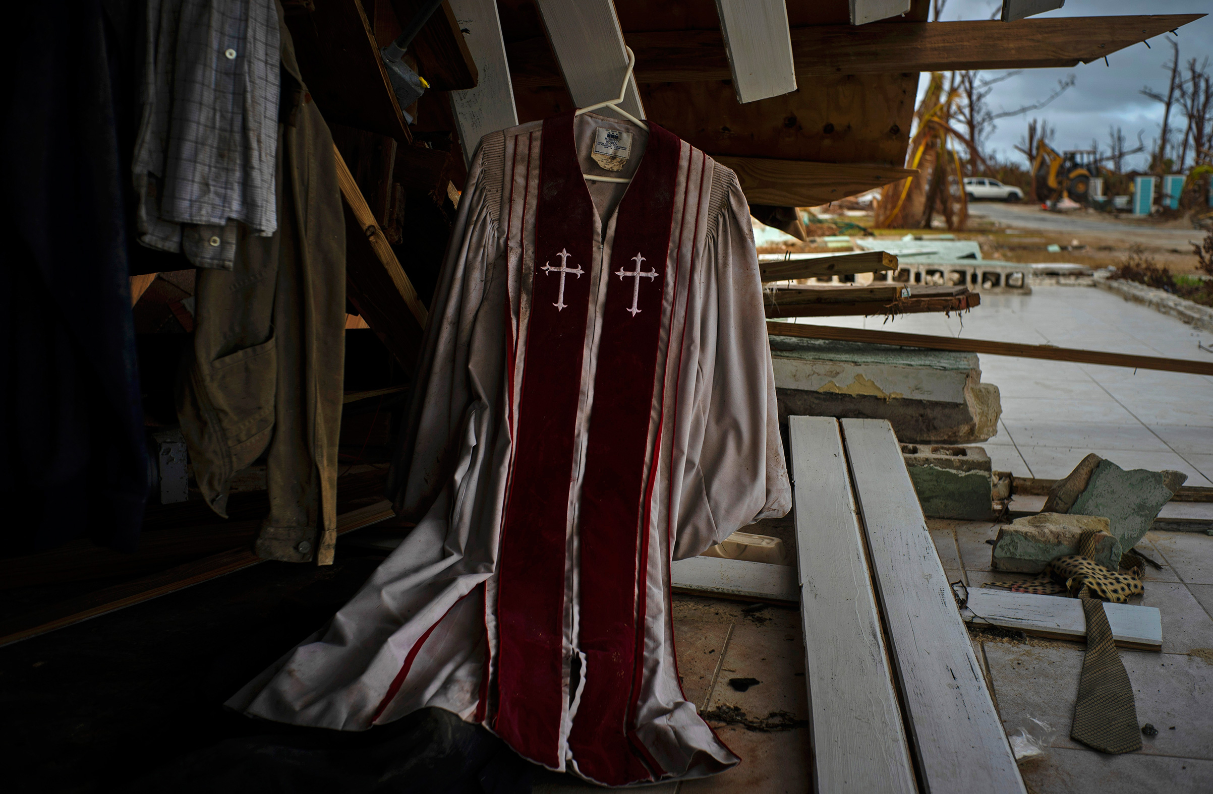 Priest's mass vestments hang in the rubble of a destroyed house by Hurricane Dorian in Pelican Point, Grand Bahama, Bahamas, Sept. 14, 2019. (Ramon Espinosa—AP)