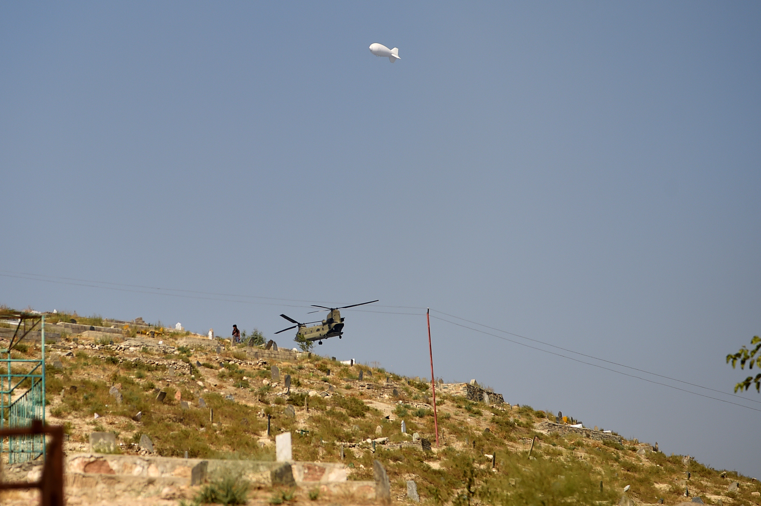A US military helicopter flies near the site of a massive explosion the night before near the Green Village in Kabul on September 3, 2019. (WAKIL KOHSAR&mdash;AFP/Getty Images)