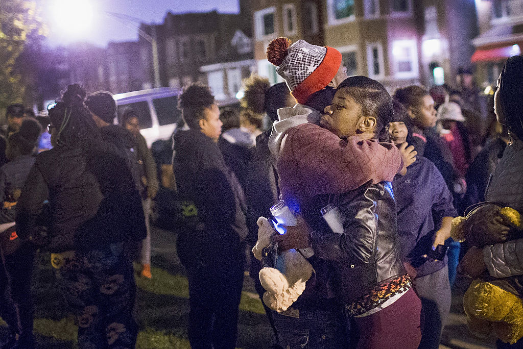 A mourner embraces Pierre Stokes, the father of 9-year-old Tyshawn Lee, during a candlelight vigil held outside his home in memory of his son on November 5, 2015 in Chicago. (Scott Olson—Getty Images)
