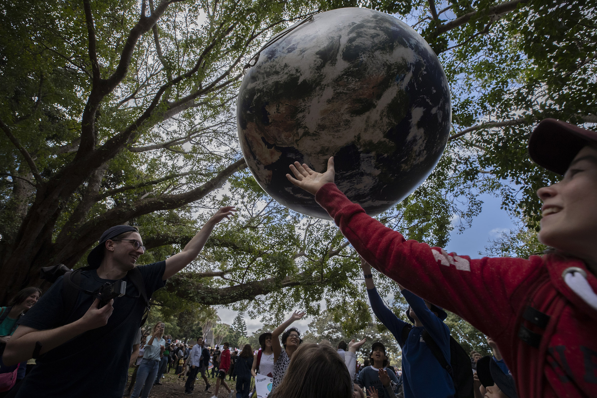 Young protestors play with a large globe on September 20, 2019 in Sydney, Australia. Rallies held across Australia are part of a global mass day of action demanding action on the climate crisis. ( (Brook Mitchell—Getty Images)