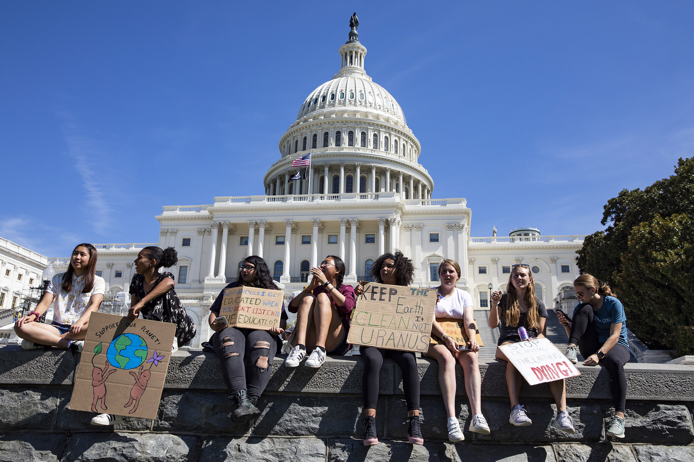 Teens sit along a wall at the U.S. Capitol during the Global Climate Strike rally on September 20, 2019 in Washington, DC. (Samuel Corum—Getty Images)