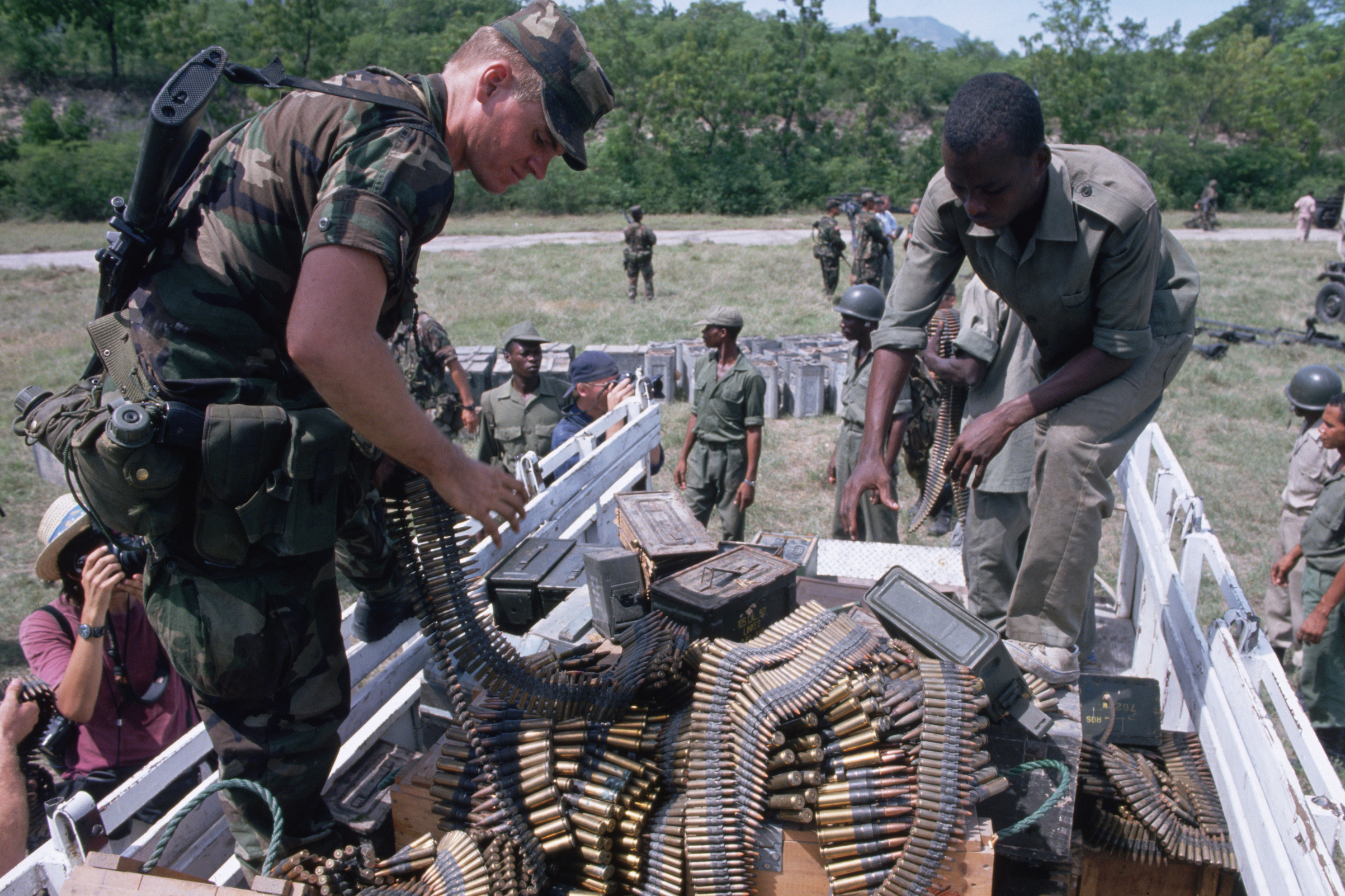 An American and Haitian soldier unload ammunition together from a supply truck in 1994. (Peter Turnley—Corbis/VCG via Getty Images)