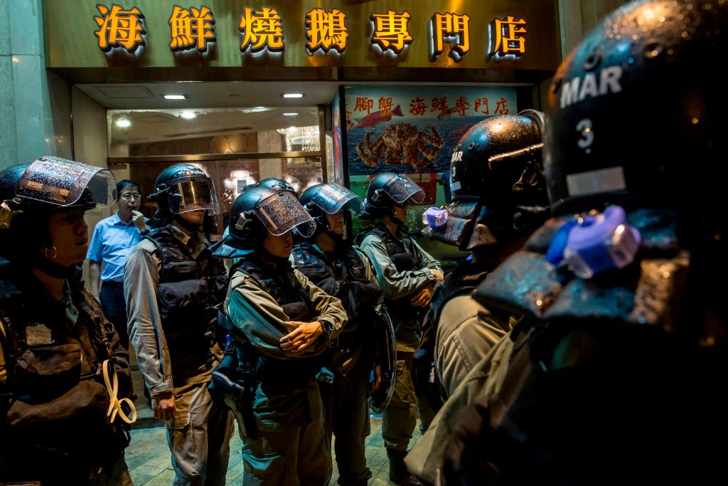 Riot police stand in front of a restaurant while patrolling after an anti-government rally in Hong Kong on August 18, 2019. (Isaac Lawrence—AFP/Getty Images)