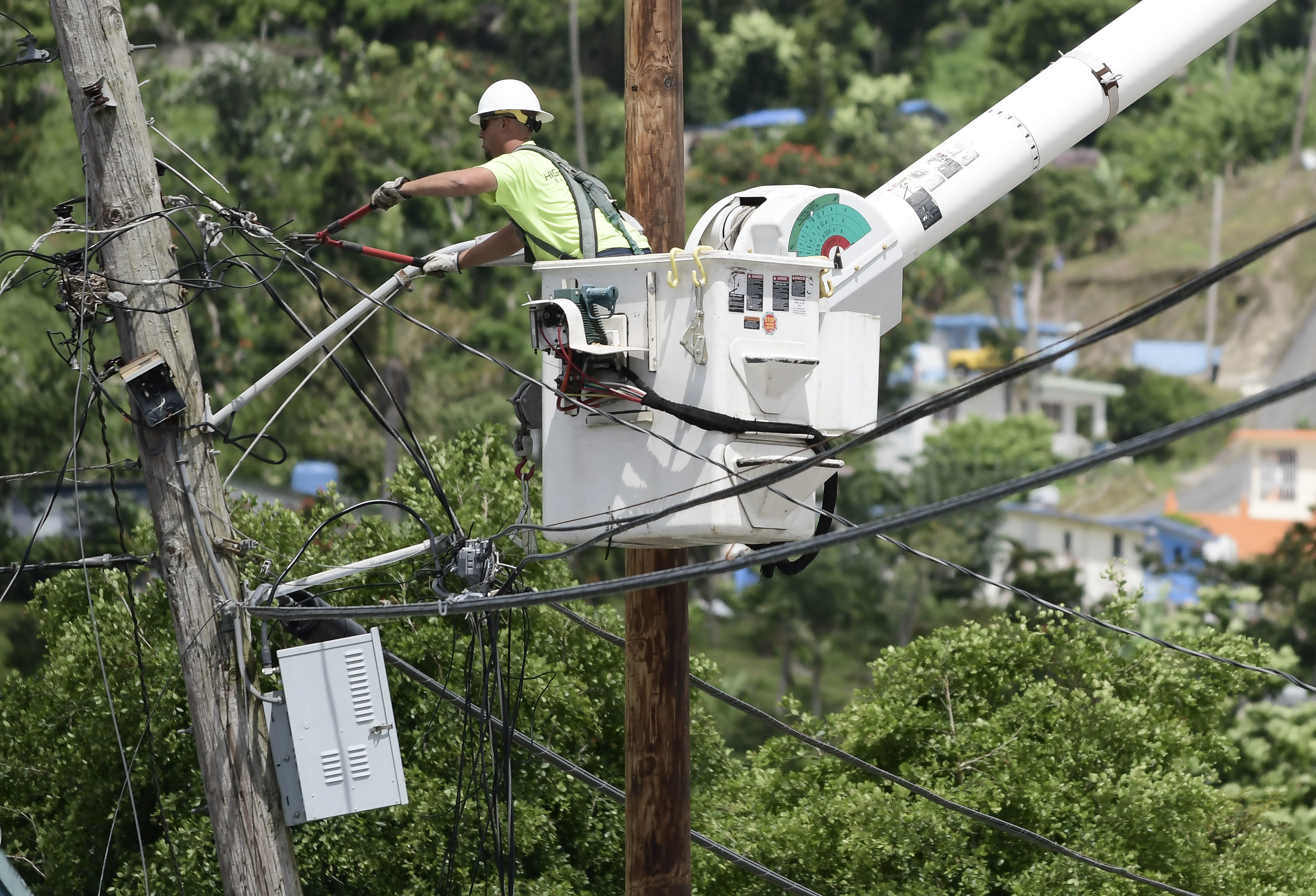 A worker from the Cobra Energy Company installs power lines in the Barrio Martorel area of Yabucoa, Puerto Rico on May 16, 2018. (Carlos Giusti&mdash;AP)