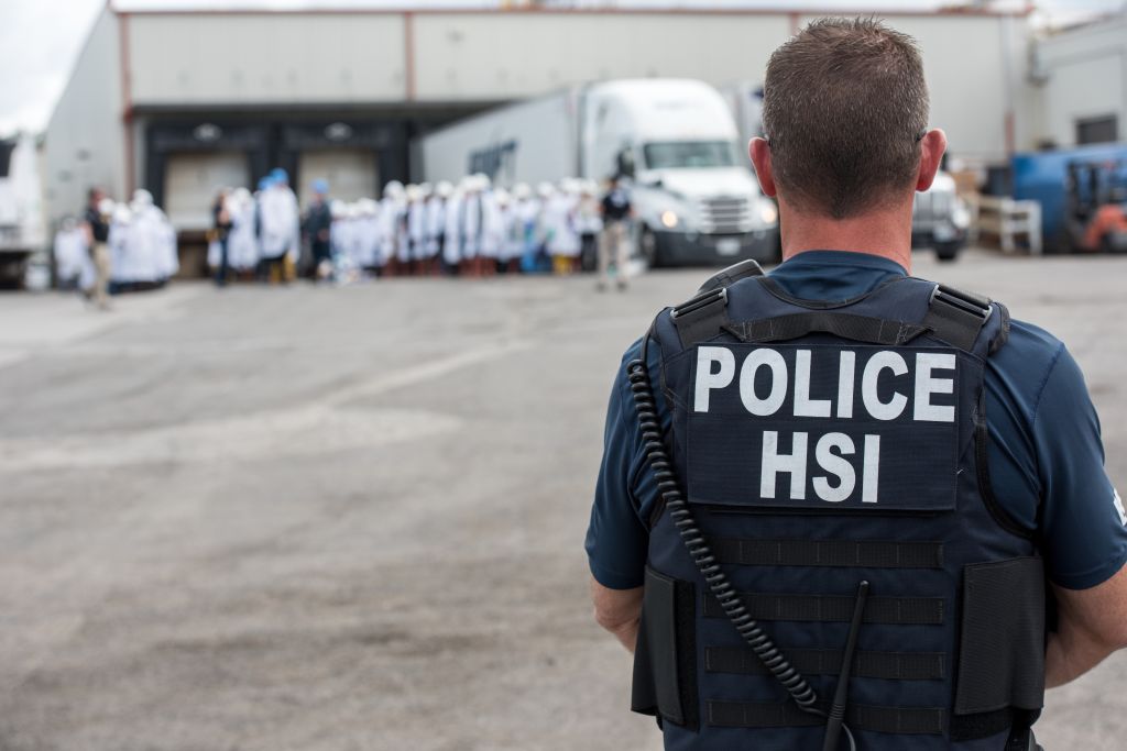 Homeland Security Investigations (HSI) special agent preparing to arrest alleged immigration violators at Fresh Mark, Salem, June 19, 2018. Image courtesy ICE ICE / U.S. Immigration and Customs Enforcement. (Smith Collection/Gado&mdash;Getty Images)