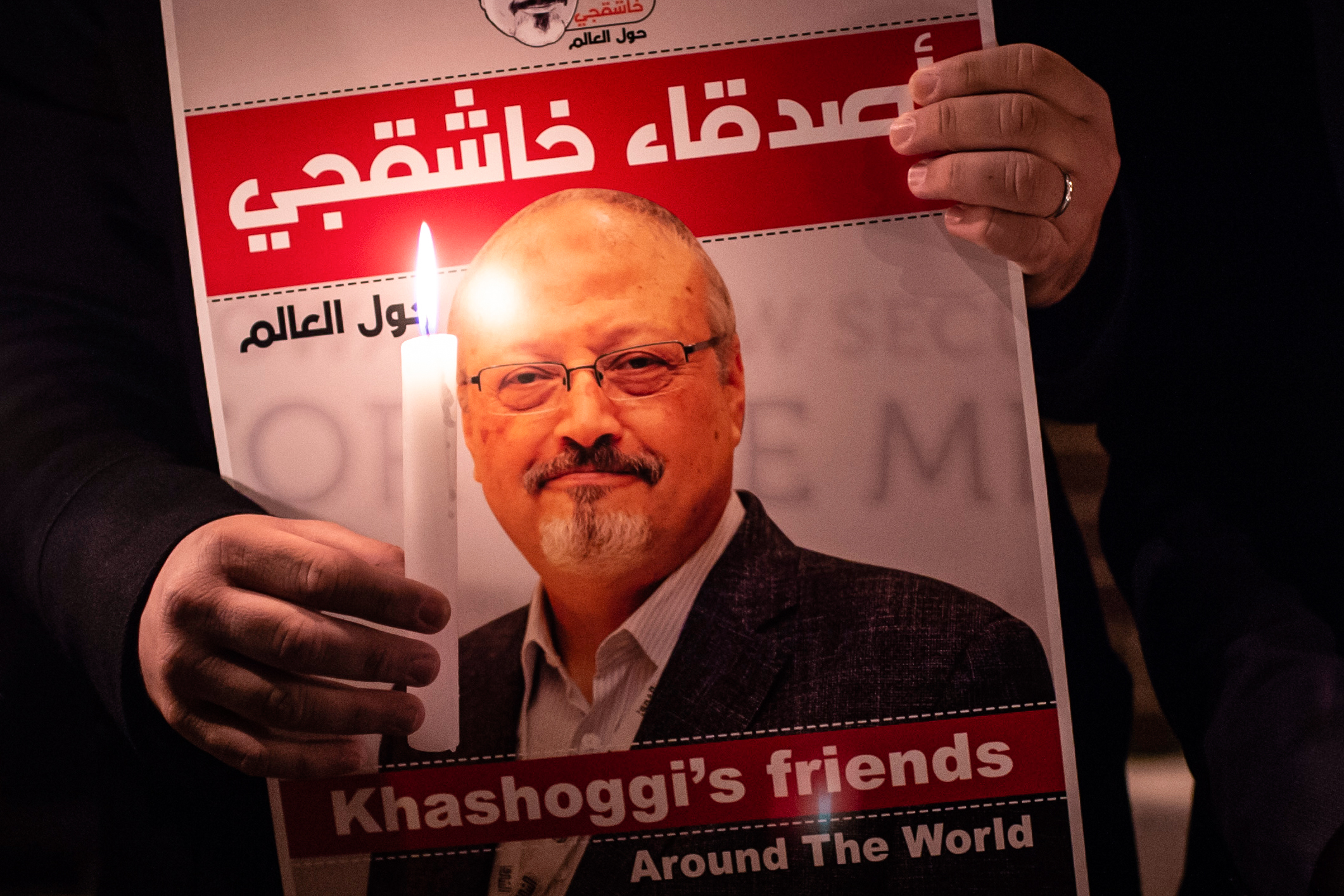 TOPSHOT - A demonstrator holds a poster picturing Saudi journalist Jamal Khashoggi and a lightened candle during a gathering outside the Saudi Arabia consulate in Istanbul, on October 25, 2018. - Jamal Khashoggi, a Washington Post contributor, was killed on October 2, 2018 after a visit to the Saudi consulate in Istanbul to obtain paperwork before marrying his Turkish fiancee. (Photo by Yasin AKGUL / AFP)        (Photo credit should read YASIN AKGUL/AFP/Getty Images) (Yasin Akgul— AFP/Getty Images)