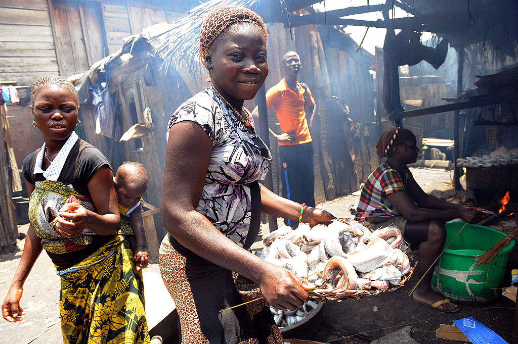 Девушка несет копченую рыбу в трущобах Макоко в Лагосе 30 августа 2012 года. (PIUS UTOMI EKPEI—AFP/Getty Images)