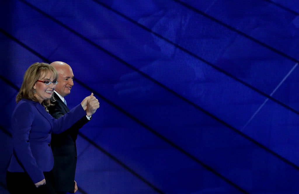 Former Congresswoman Gabby Giffords and her husband, retired NASA Astronaut and Navy Captain Mark Kelly, hold hands as they walk off stage after delivering remarks on the third day of the Democratic National Convention at the Wells Fargo Center, July 27, 2016 in Philadelphia, Pennsylvania. (Alex Wong—Getty Images)