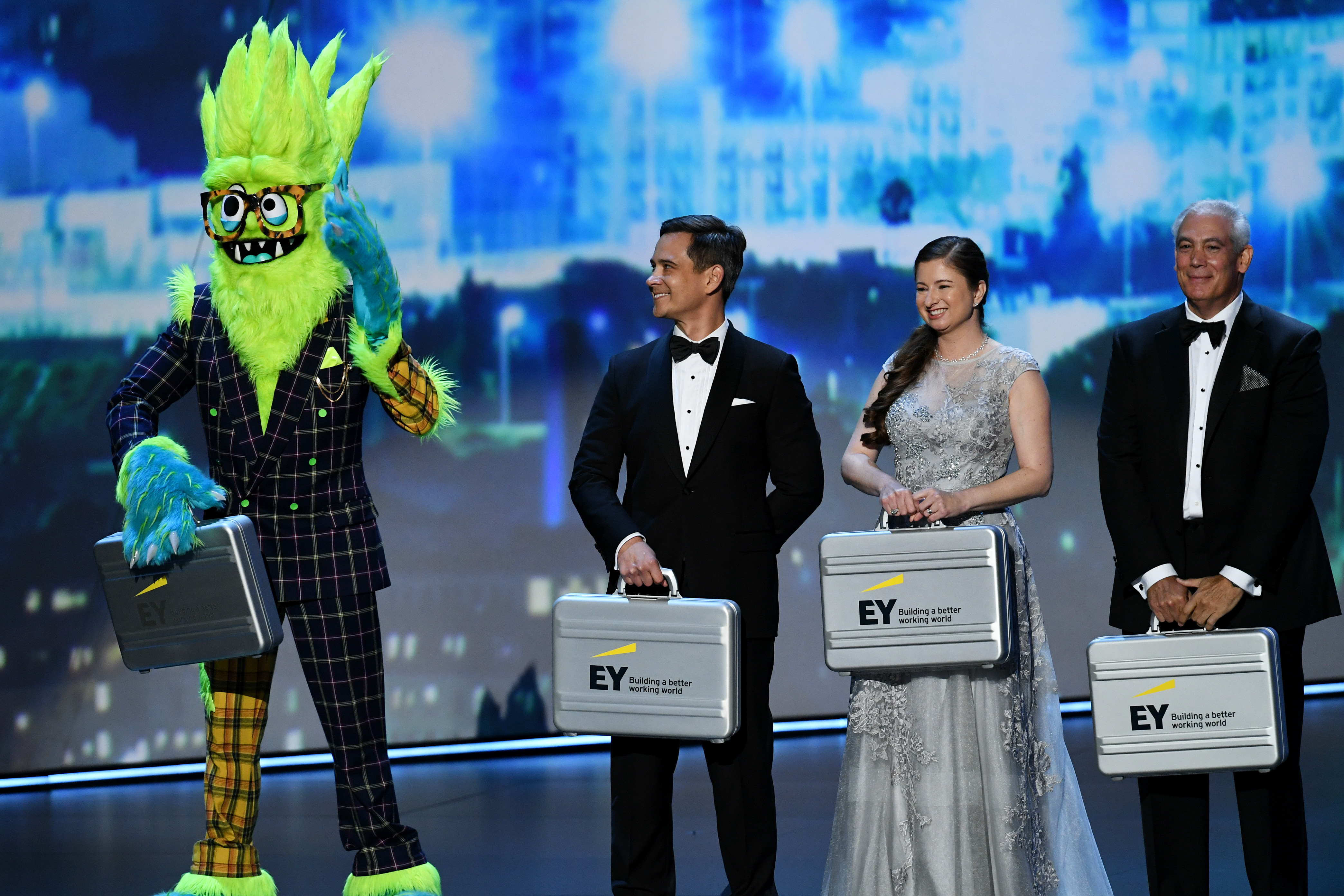 A character from 'The Masked Singer' and Ernst &amp; Young representatives appear onstage during the 71st Emmy Awards. (Kevin Winter—Getty Images)