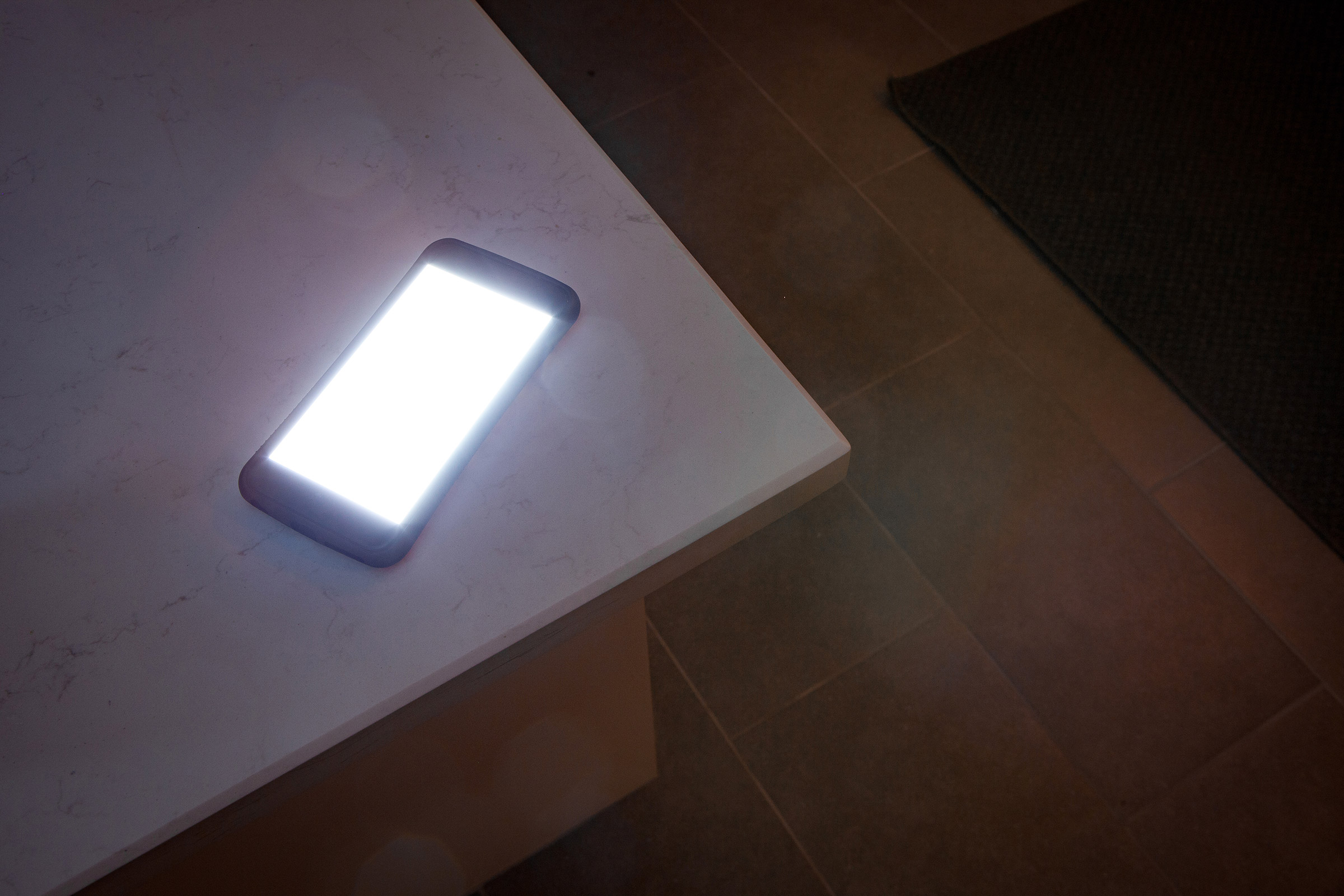 Glowing smartphone on countertop at night