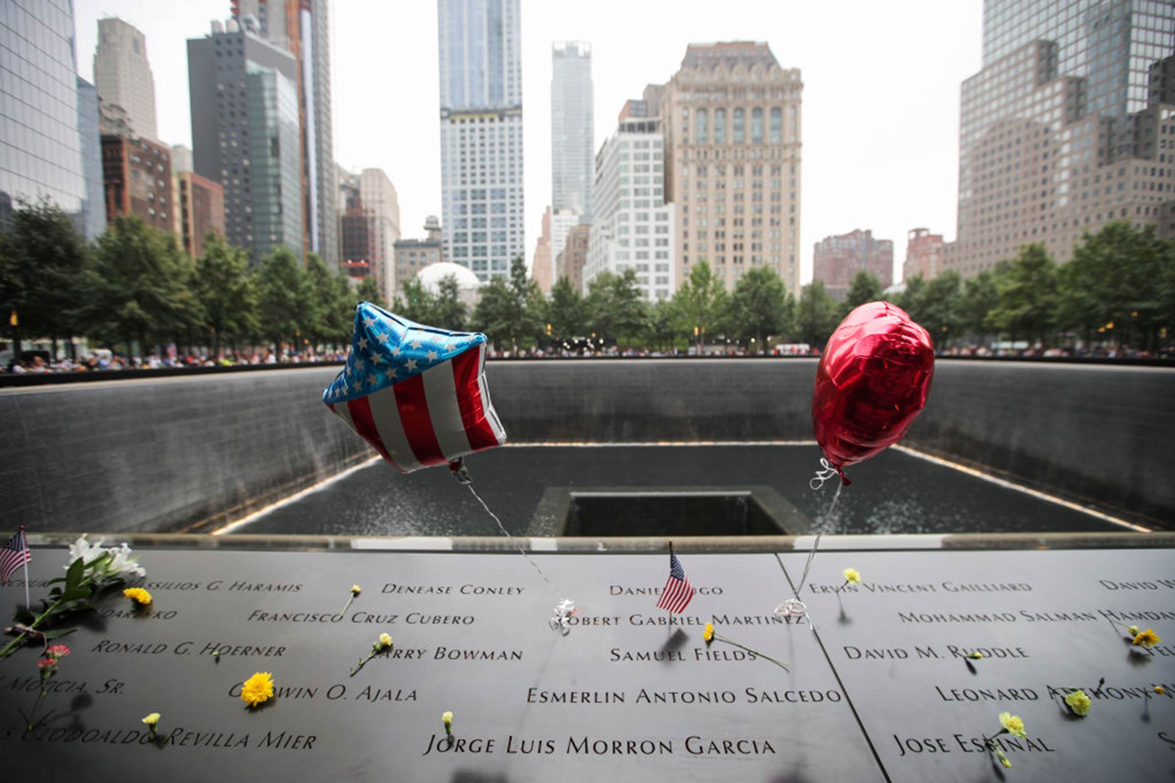 Flowers and balloons are placed on plates on which the names of 9/11 victims were inscribed around the South Pool at the 9/11 Memorial and Museum in New York City on Sept. 11, 2018. (Wang Ying—Xinhua/Getty Images)