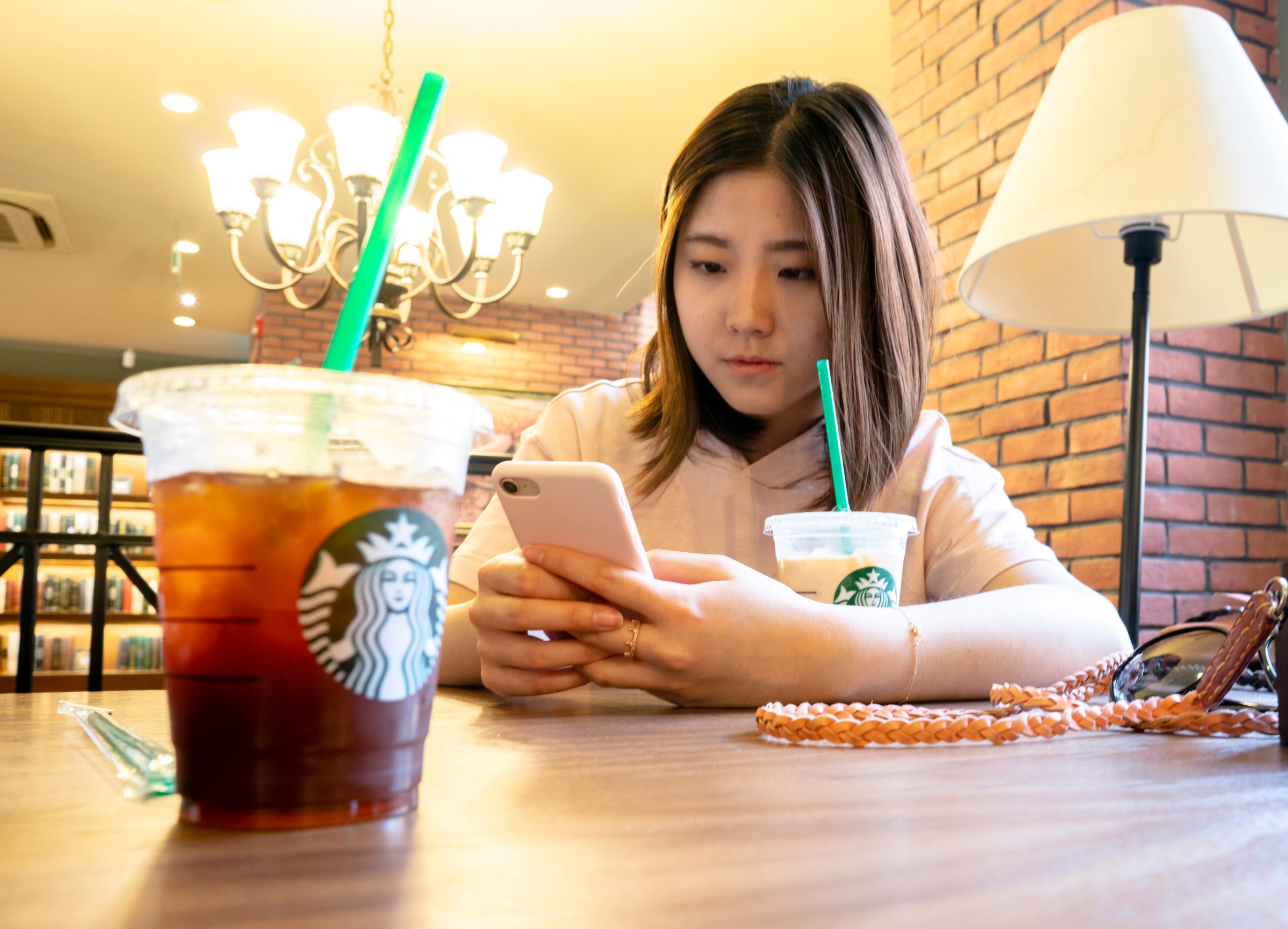 A girl is drinking ice coffee in a Starbucks coffee shop.