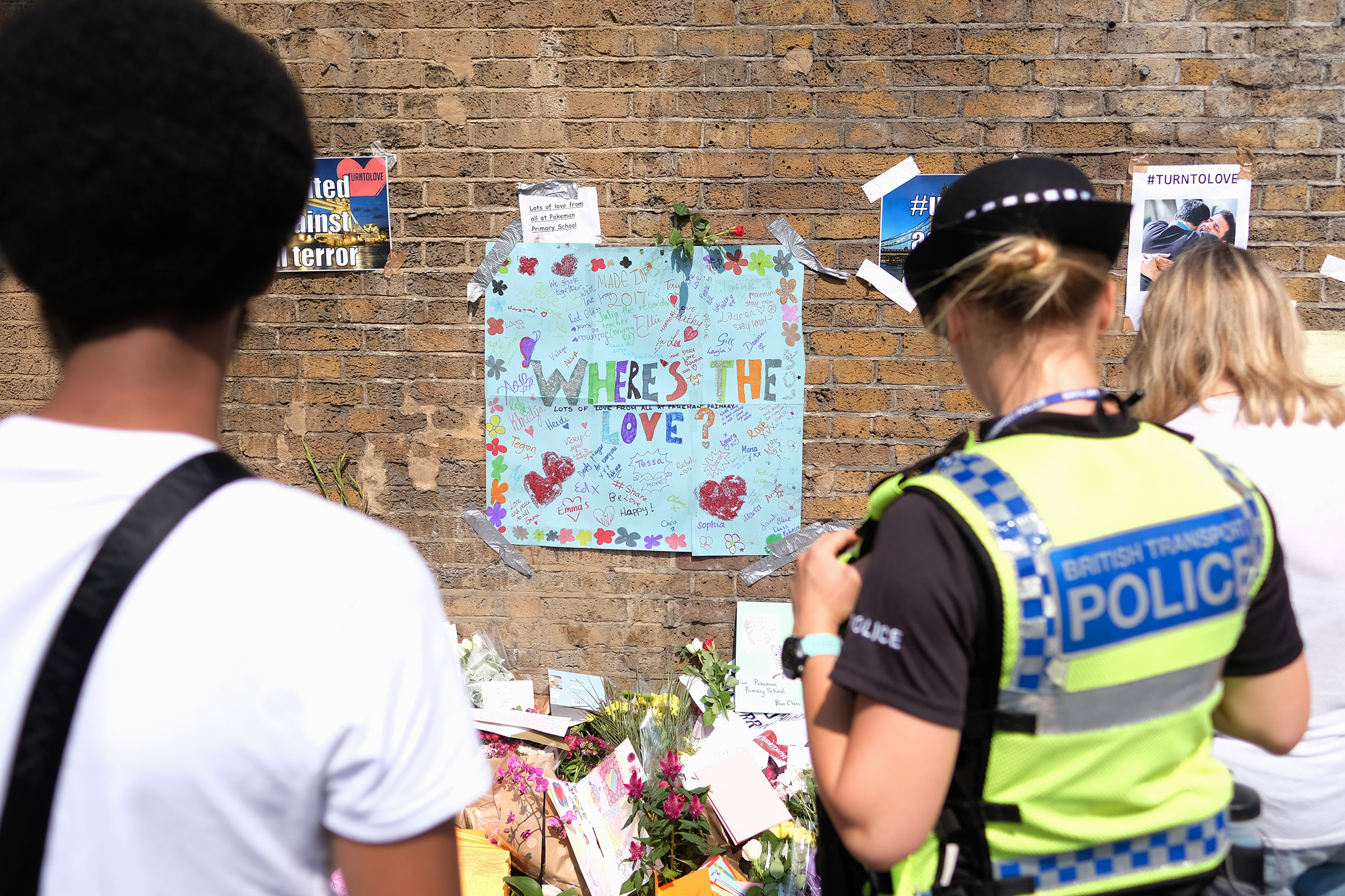 People stop to read some of the messages of support and love for the Muslim community near Finsbury Mosque on June 20, 2017 in London. A man was held on suspicion of attempted murder and alleged terror offenses after a group of Muslims were hit by a van in Finsbury Park. (Leon Neal—Getty Images)