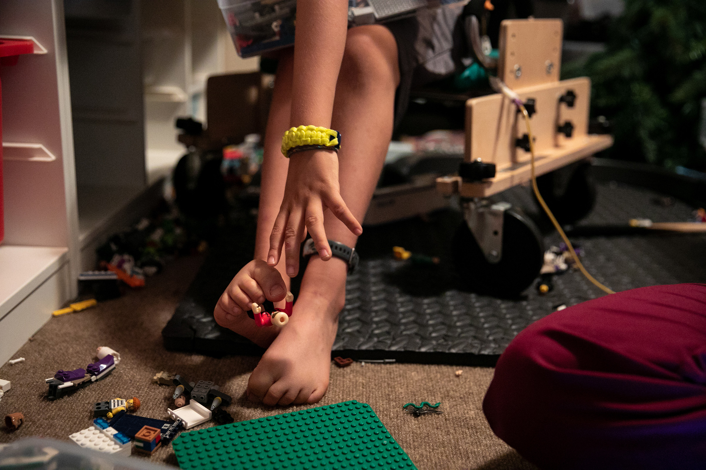 Braden uses his toes to reach for a LEGO on a break inbetween physical therapy treatments.