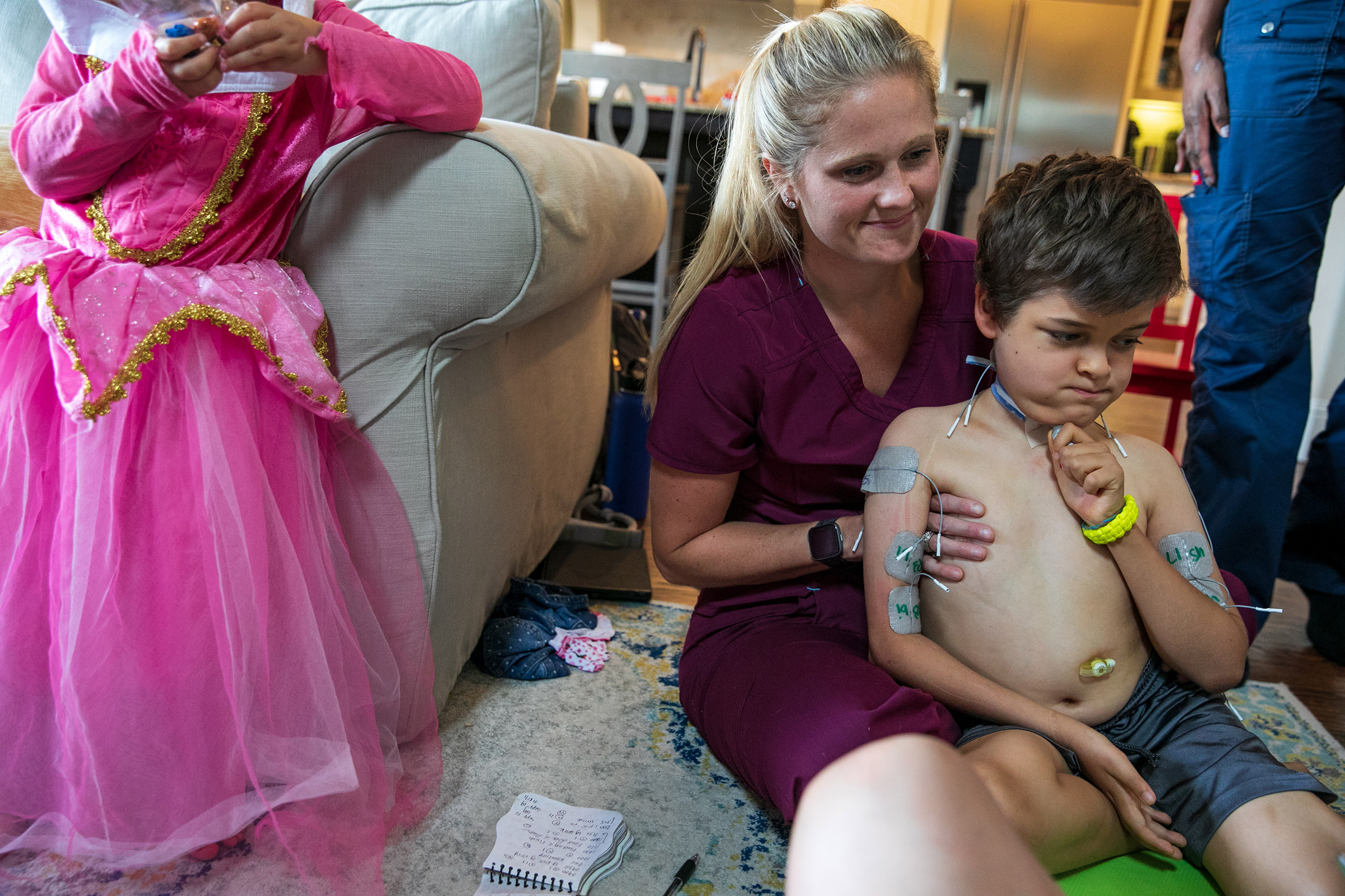 One of Braden's nurses, Carly Westcott, RN, helps prepare him for therapy.