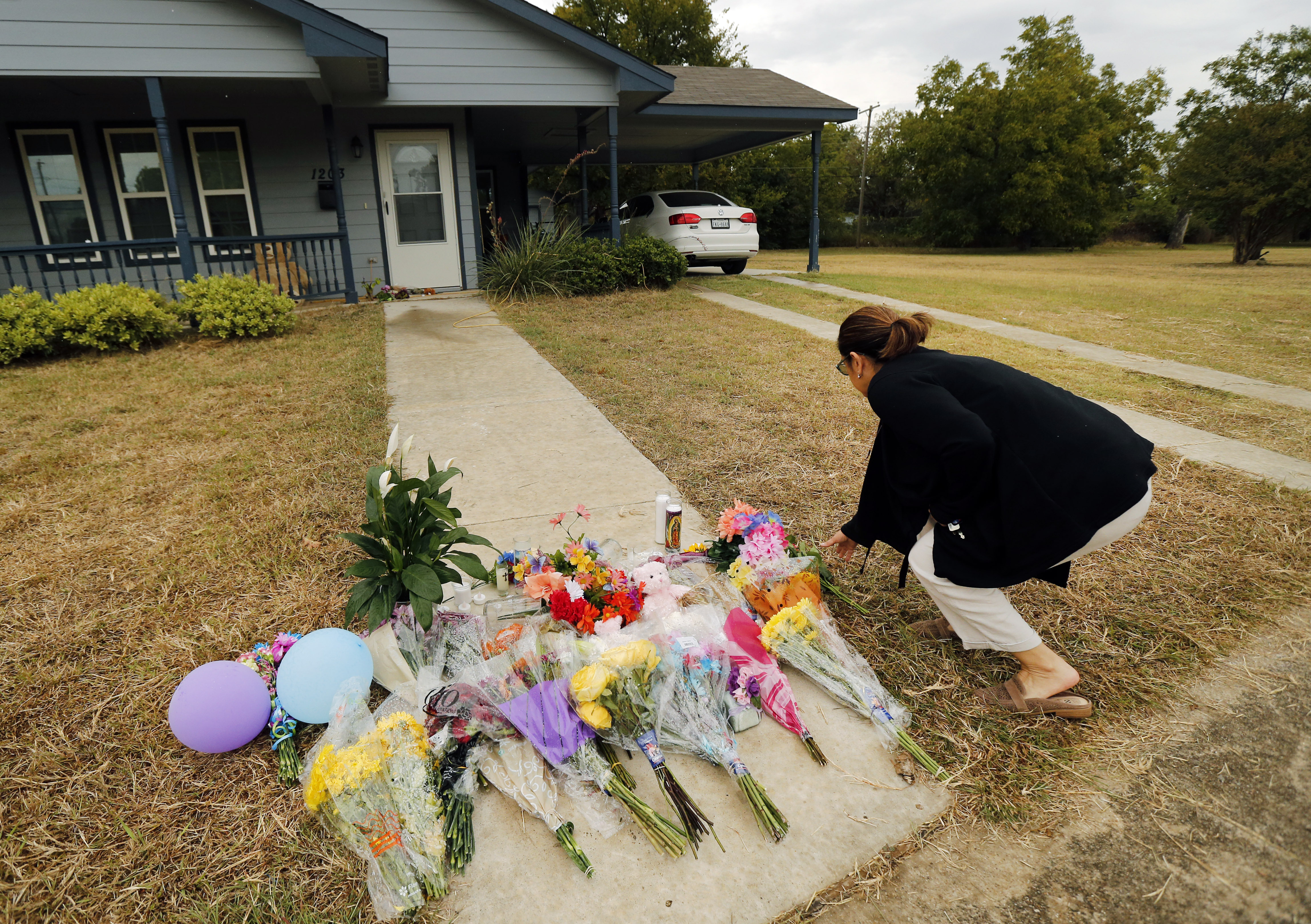 Anastasia Gonzalez, of Burleson, Texas, leaves a flowers on the front sidewalk of Atatiana Jefferson's home on E. Allen Ave in Fort Worth on Oct. 15, 2019. (Tom Fox—The Dallas Morning News/AP)