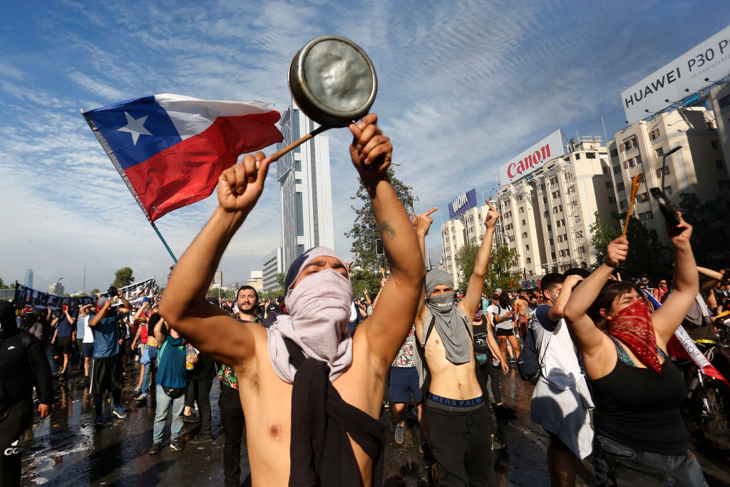 Demonstrators display flags and banners during a protest against President Sebastian Piñera on Oct. 21, 2019 in Santiago, Chile, as protests continue into eighth day. (Marcelo Hernandez)