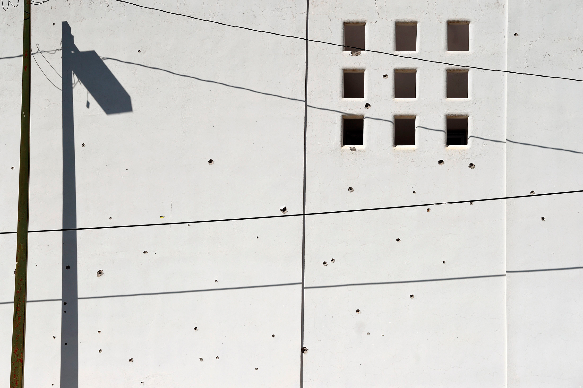 A wall is pockmarked with bullet holes in Culiacan, Mexico, on Oct. 18, 2019.