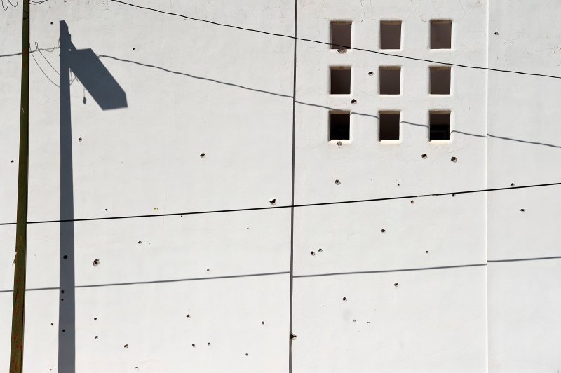 A wall is pockmarked with bullet holes in Culiacan on Oct. 18.