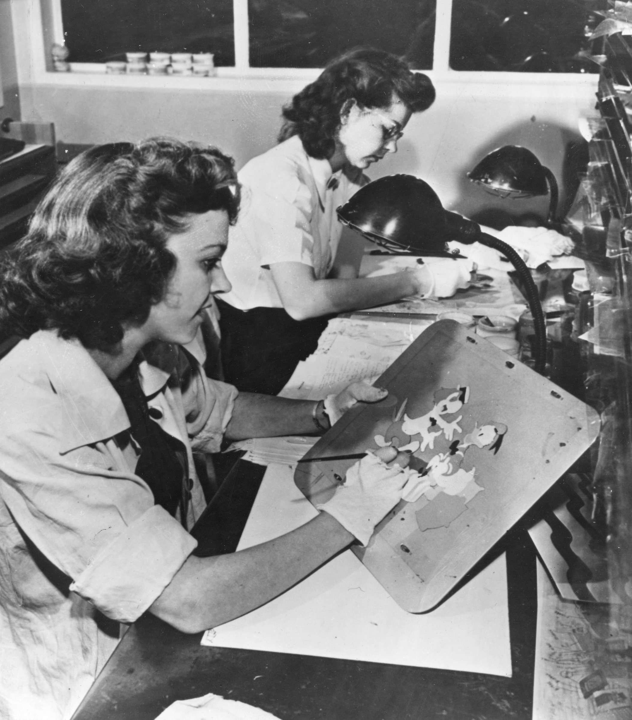 Two unidentified artists paint animation cels in Disney Studios' inking and painting department, Burbank, Calif., 1943. (PhotoQuest/Getty Images)