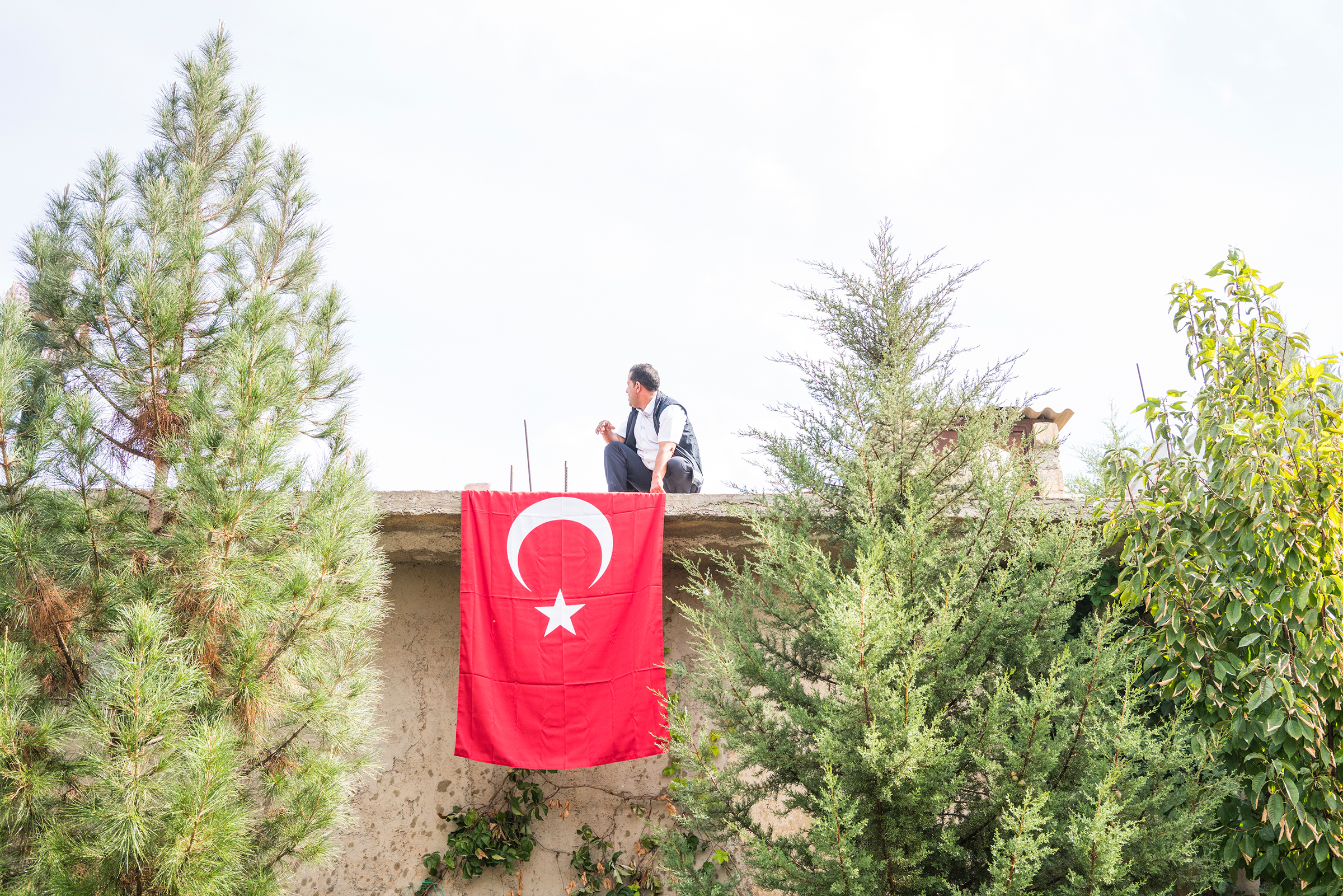 A man places a Turkish flag in the courtyard of a mosque before the funeral of a nine-month-old Syrian baby, who was killed during rocket and mortar attacks in Akçakale, Turkey, on Oct. 11, 2019.