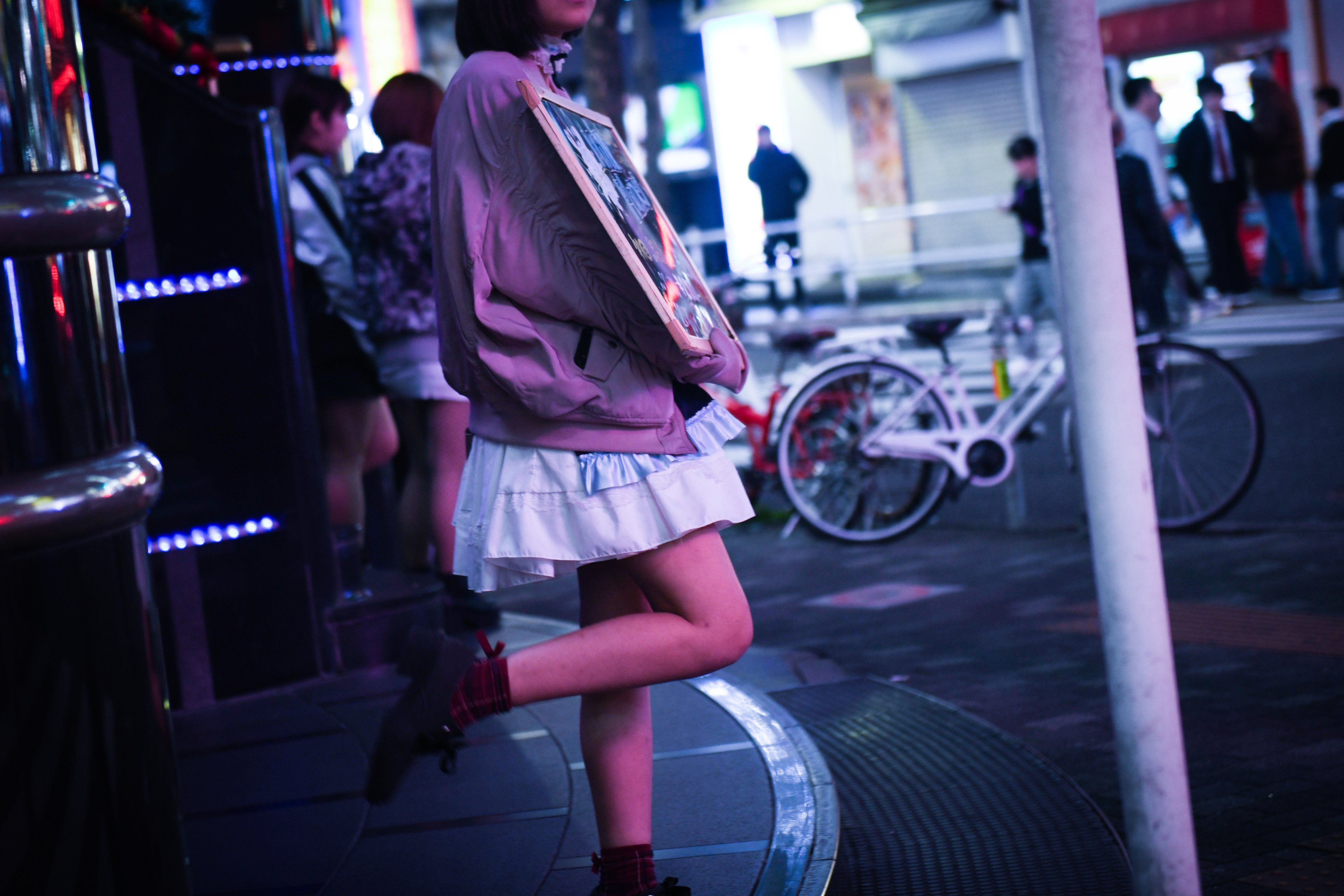 A woman holds an advertisement for a girls bar in the Shinjuku district of Tokyo, Japan, on Wednesday, July 21, 2018. (Noriko Hayashi/Bloomberg via Getty Images)