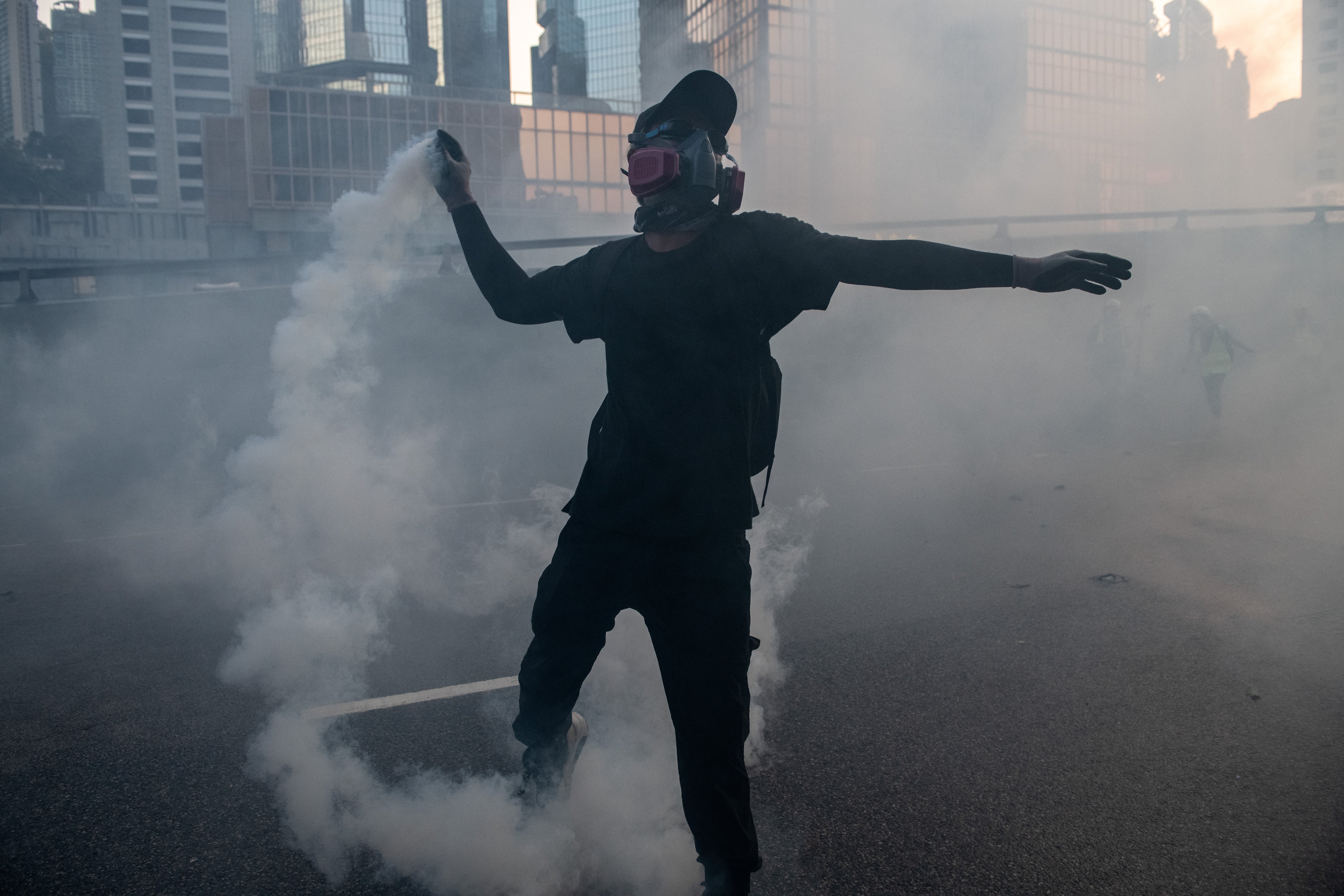 A pro-democracy protester throws a police teargas cartridge back at police officers in the Central Government Offices on September 15, 2019 in Hong Kong, China. (Carl Court—Getty Images)