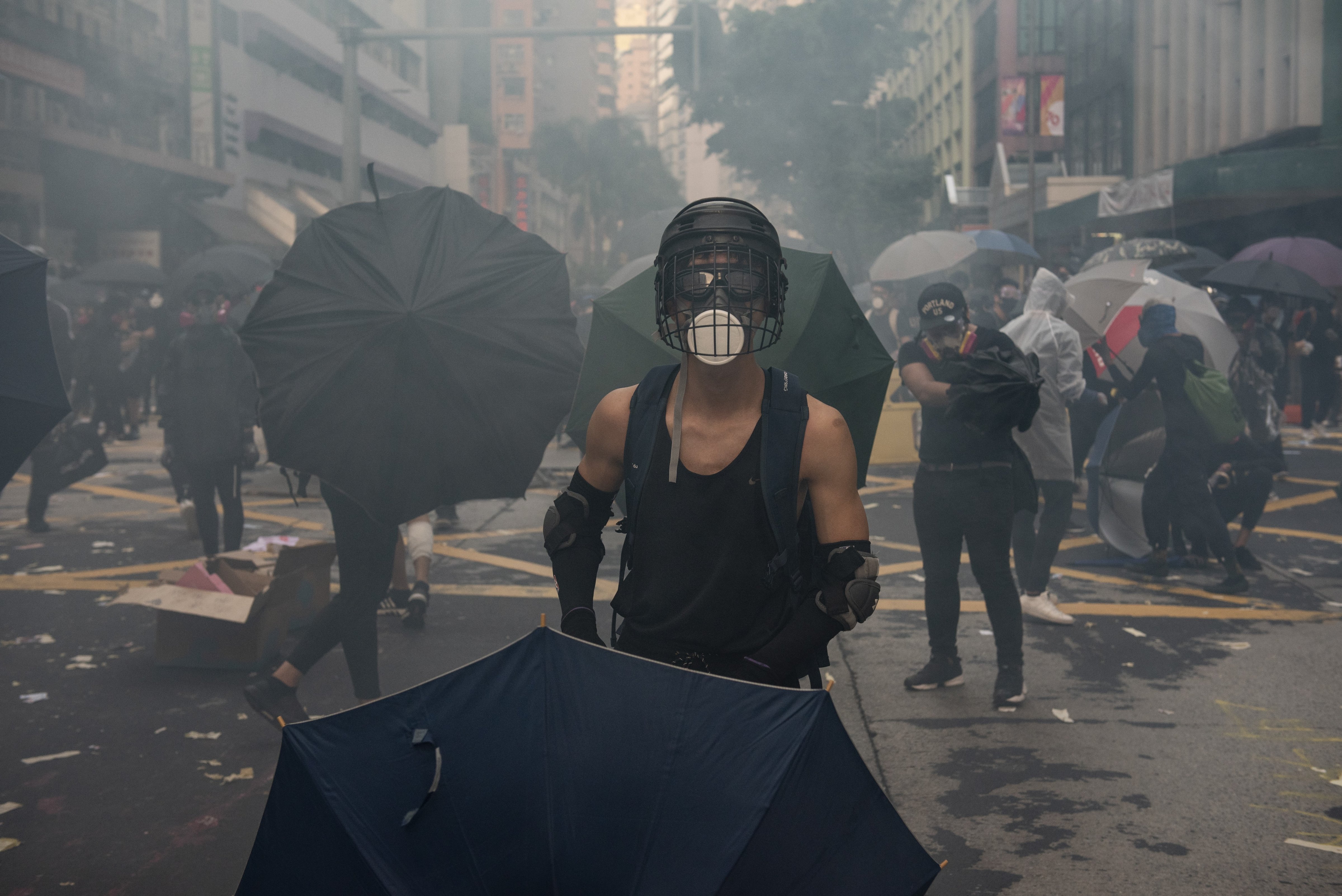 A protester holds an umbrella surrounded by tear gas as thousands of anti-China protesters clash with police in Hong Kong on October 01, 2019. (Miguel Candela Poblacion/Anadolu Agency via Getty Images)