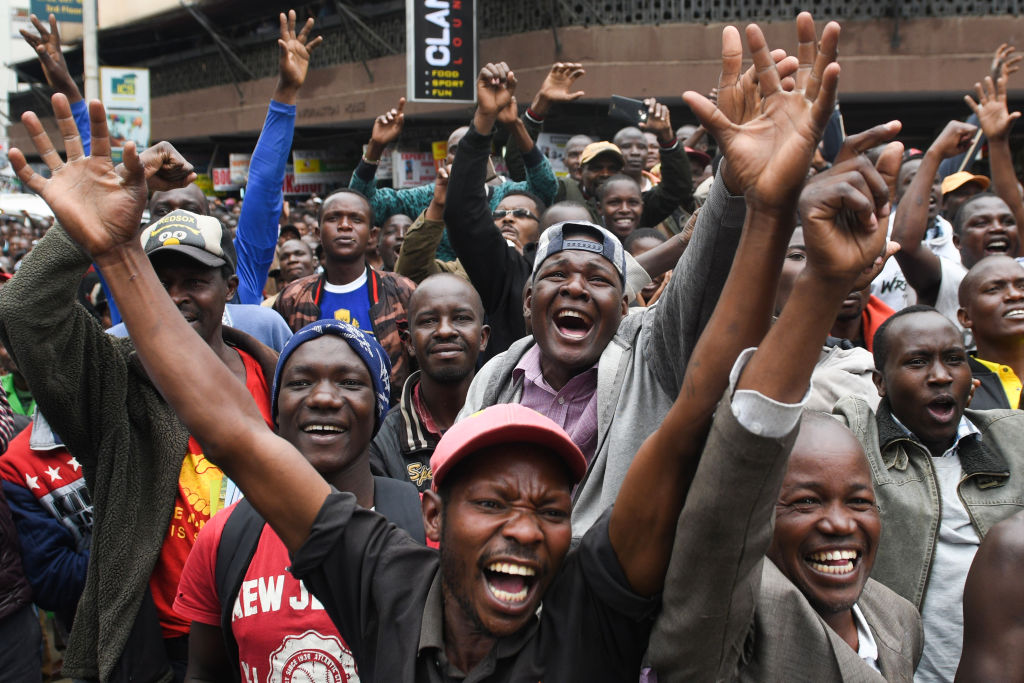 Kenyans watch a big screen on October 12, 2019, in Nairobi as they celebrate Kenya's Eliud Kipchoge victory. (SIMON MAINA—AFP via Getty Images)