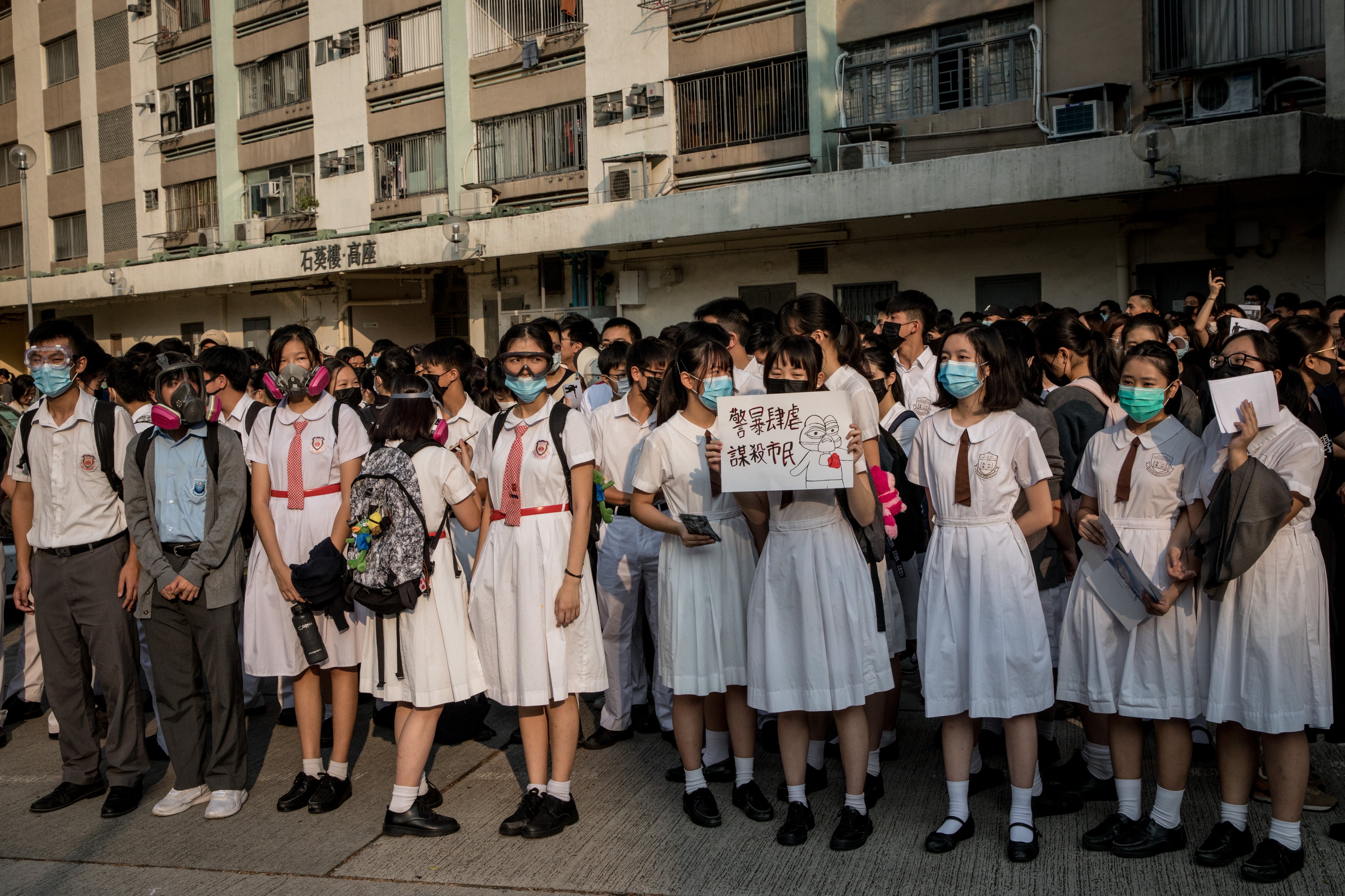 Schoolmates of a protester who was shot by a policeman during the October 1 protests, take part in a solidarity rally outside the Tsuen Wan Public Ho Chuen Yiu Memorial College on October 02, 2019 in Hong Kong, China. (Chris McGrath—Getty Images)