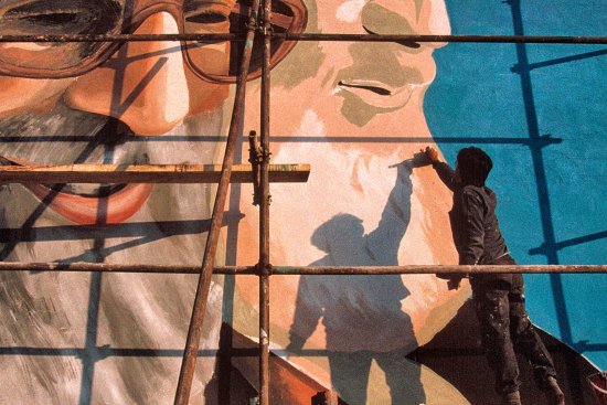 A painter works on a Tehran mural of Khamenei, left, and Iran’s first Supreme Leader, Ruhollah Khomeini