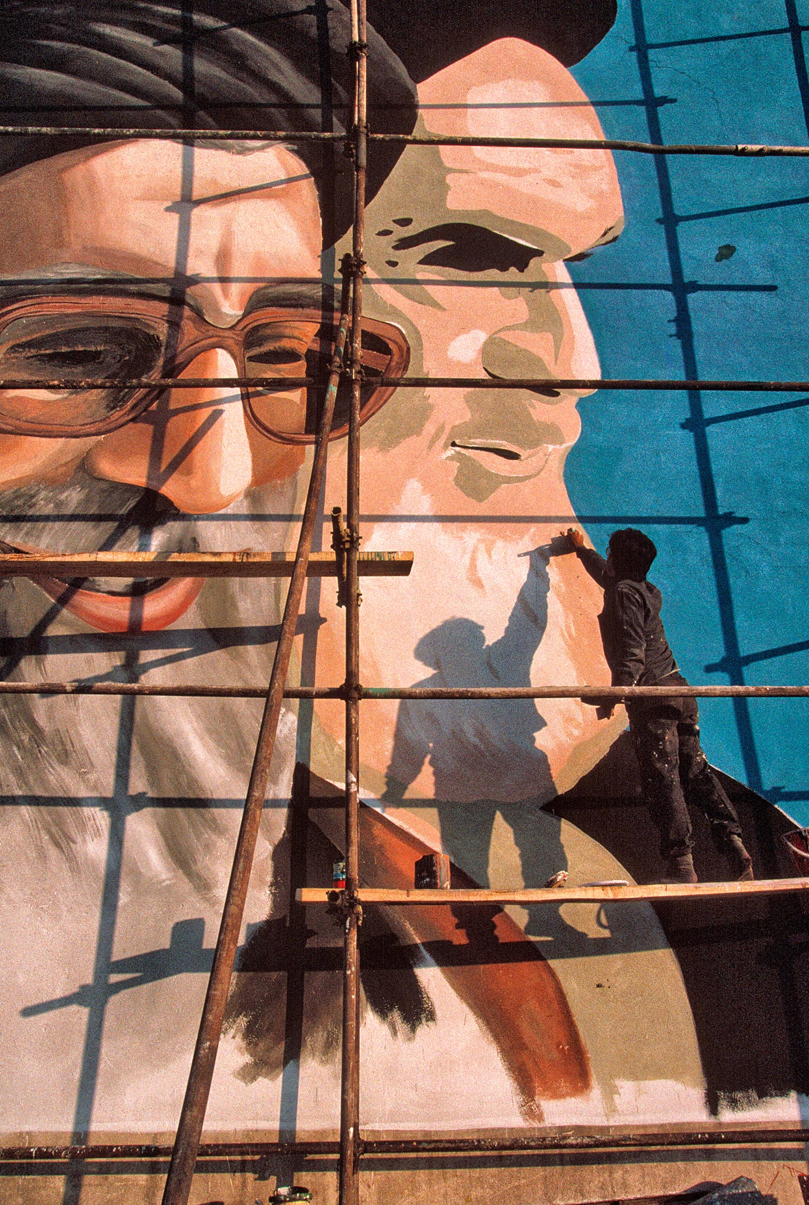 A painter works on a Tehran mural of Khamenei, left, and Iran’s first Supreme Leader, Ruhollah Khomeini (A. Abbas—Magnum Photos)