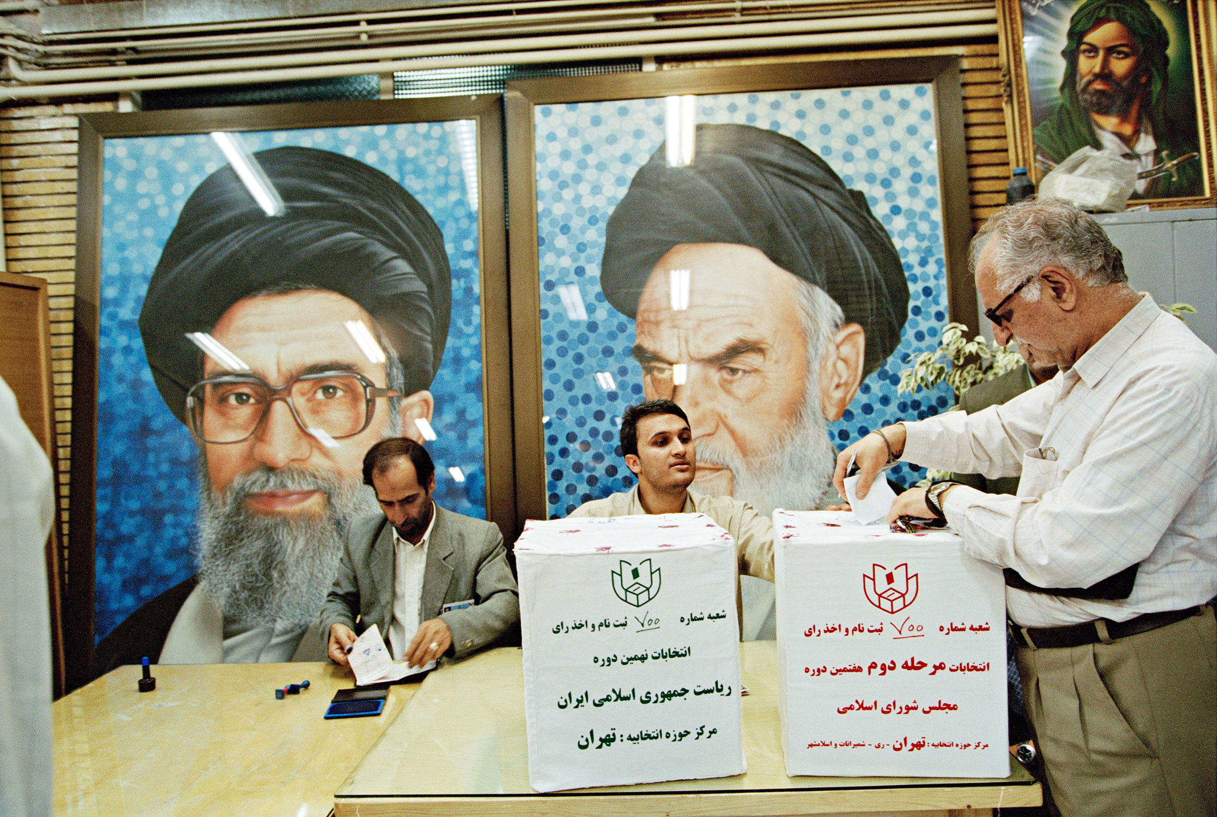 Portraits of Khamenei and his mentor and predecessor, Khomeini (right), at a Tehran polling place in June