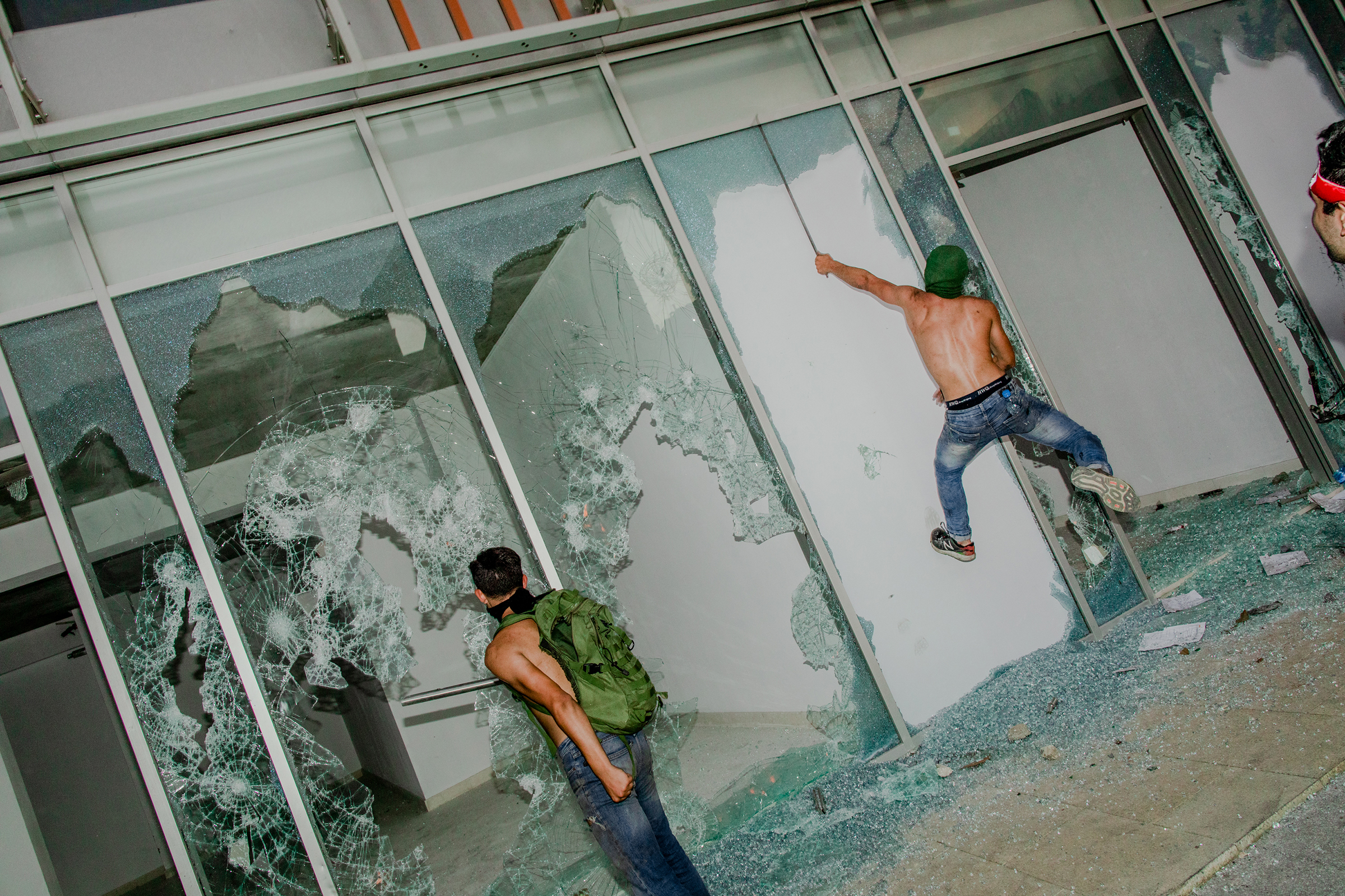 Young men smashing shop windows on the first day of protests in Beirut on Oct. 18, 2019. (Myriam Boulos)
