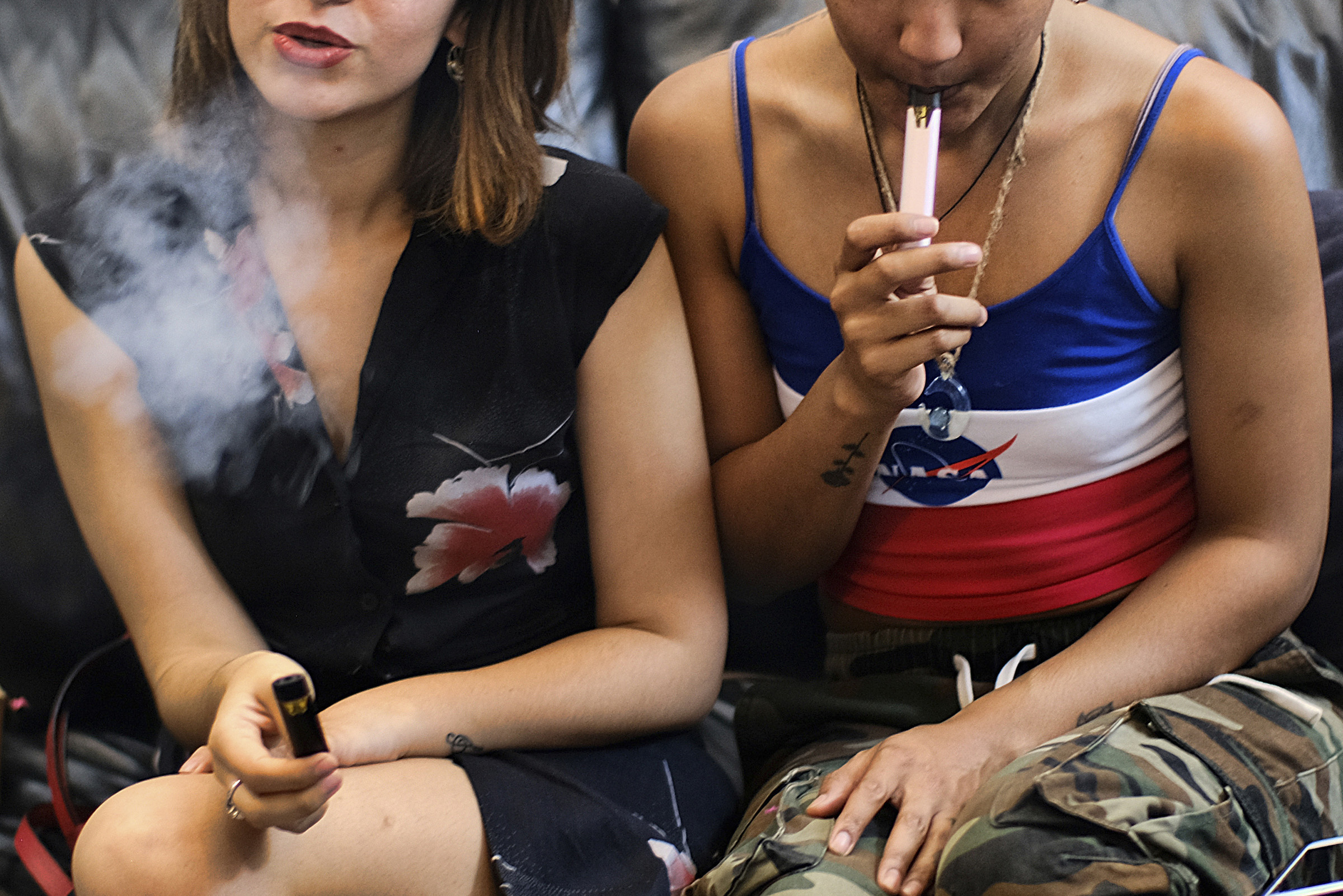 Two women smoke cannabis vape pens at a party in Los Angeles on June 8, 2019. (Richard Vogel—AP)