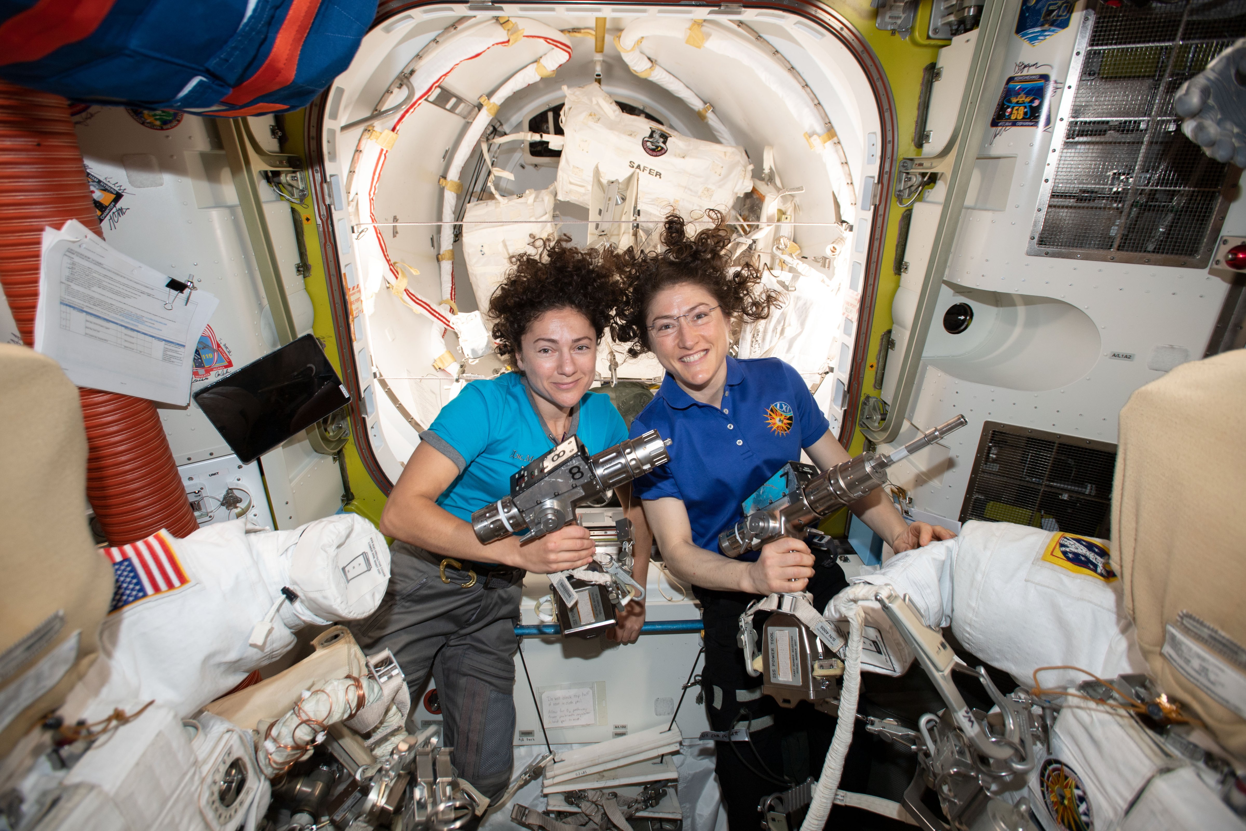 NASA astronauts Jessica Meir (left) and Christina Koch inside the Quest airlock preparing the U.S. spacesuits and tools they will use on their first spacewalk together. (NASA)