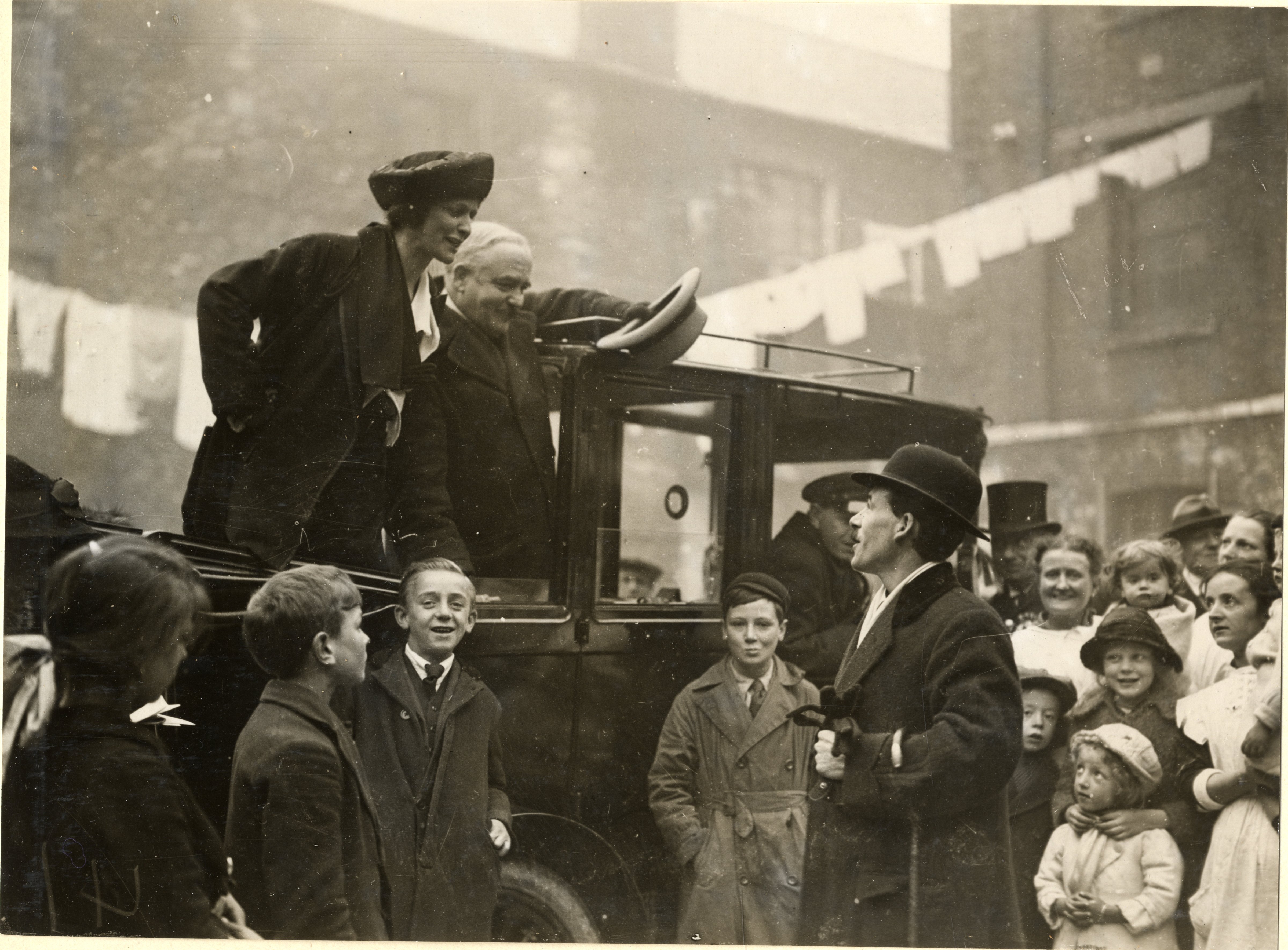 A photograph of Nancy Astor standing in the back of a car and talking to a man in the crowd at Clare Buildings, Coxside (1)