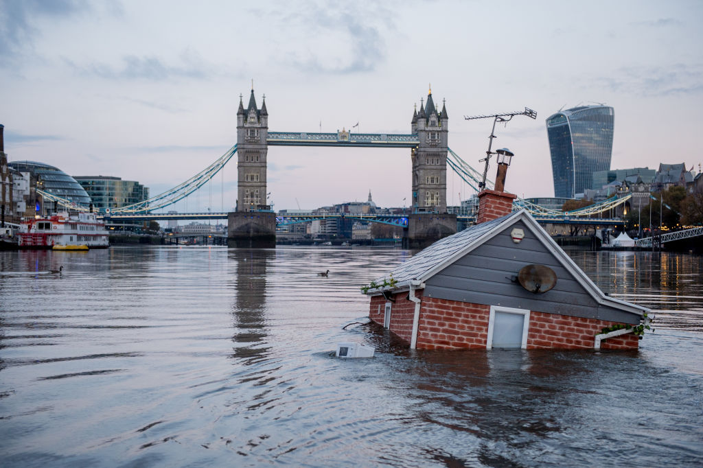 Environmental protest group Extinction Rebellion floats a replica of a British house in front of Tower Bridge on the river Thames in an action entitled 'Our House Is Flooding' on November 10, 2019 in London, England. (Ollie Millington – Getty Images)