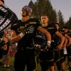 Members of the Paradise High School football team stand for the playing of the national anthem before their game against Williams High School in Paradise, Calif., on Aug. 23, 2019.