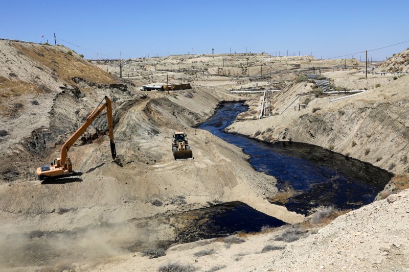 A crew works on seepage of 800,000 gallons of oil and brine water oil from an abandoned well in Chevron Corp's Cymric Oil Field in McKittrick, Calif., on July 24, 2019.