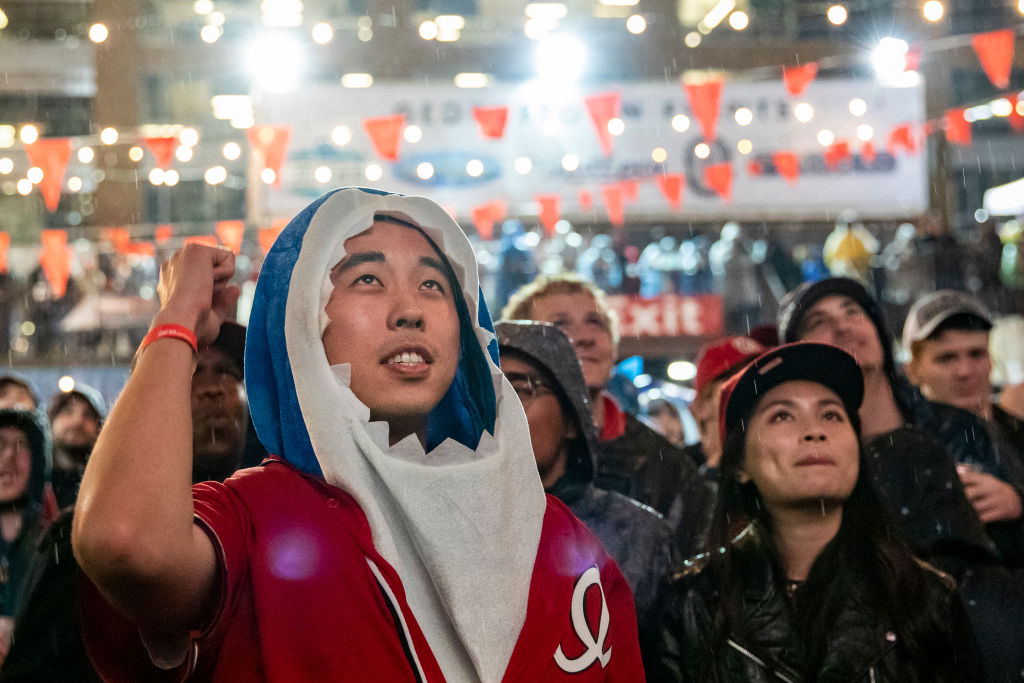 Michael Qu, from Northern Virginia wearing a Baby Shark costume watches the World Series Game 7 on a big screen with other fans in the rain just a block from Nats Park at The Bullpen on October 30, 2019 in Washington, DC. The Washington Nationals are facing off against the Houston Astros after forcing a Game 7 in the World Series in Houston last night and fans are showing up in droves to cheer on the Nationals in and around Nats Park in South East, D.C. (Samuel Corum&mdash;Getty Images)
