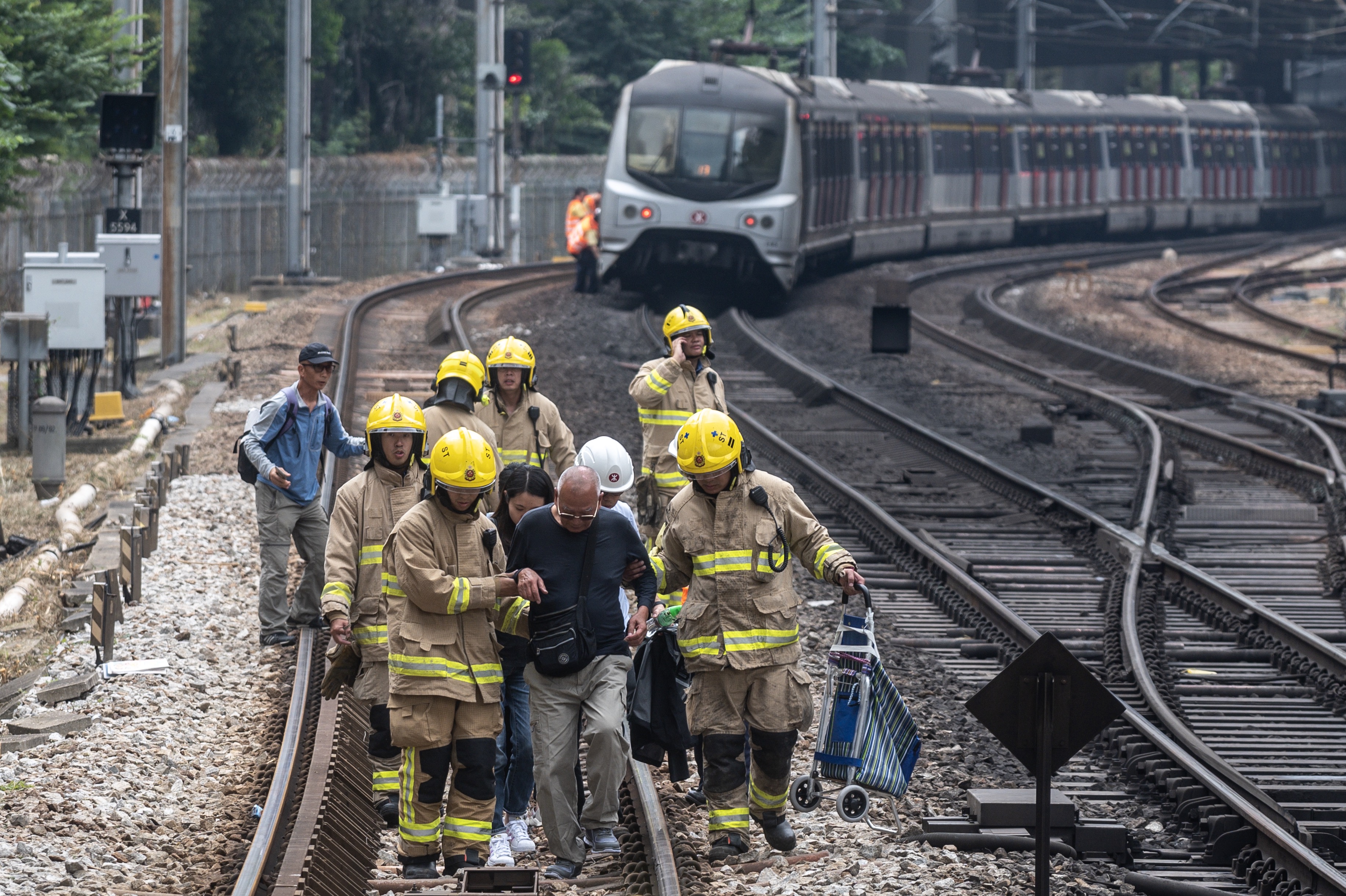 A man is escorted by firemen on the train tracks at Sha Tin MTR station due to the disruption of the train services in Hong Kong on November 12, 2019. (PHILIP FONG—AFP via Getty Images)