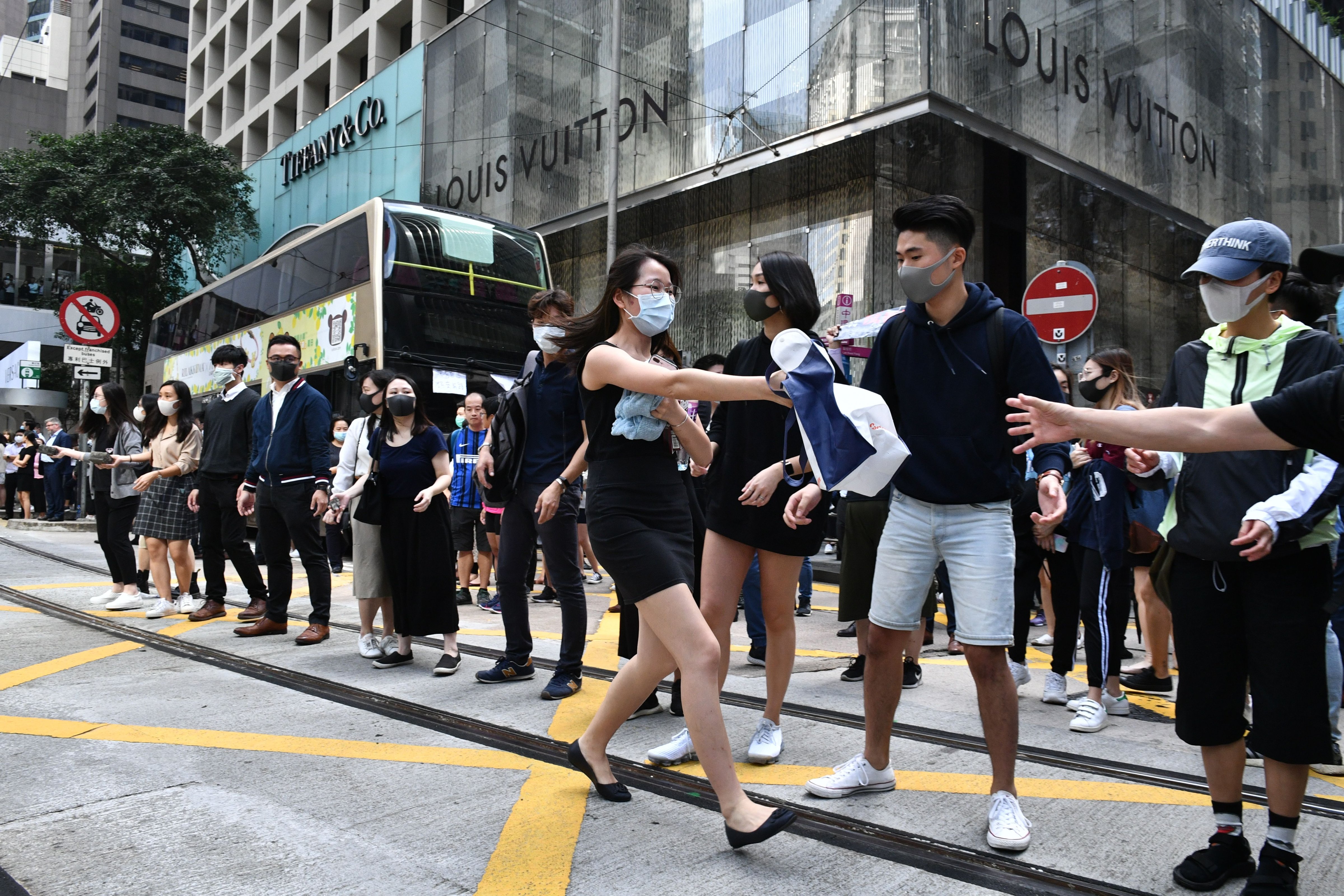 Office workers and pro-democracy protesters form a human chain to pass bricks during a demonstration in Central in Hong Kong on November 12, 2019. (ANTHONY WALLACE—AFP via Getty Images)